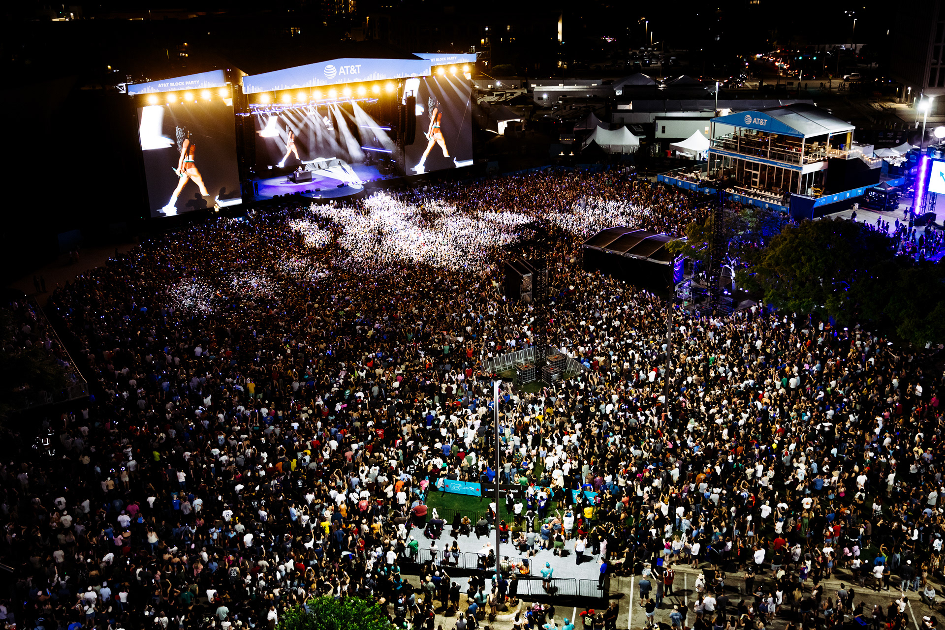 aerial view of a massive festival crowd in front of a lit main stage at dusk, San Antonio festival photographer Chris Stokes