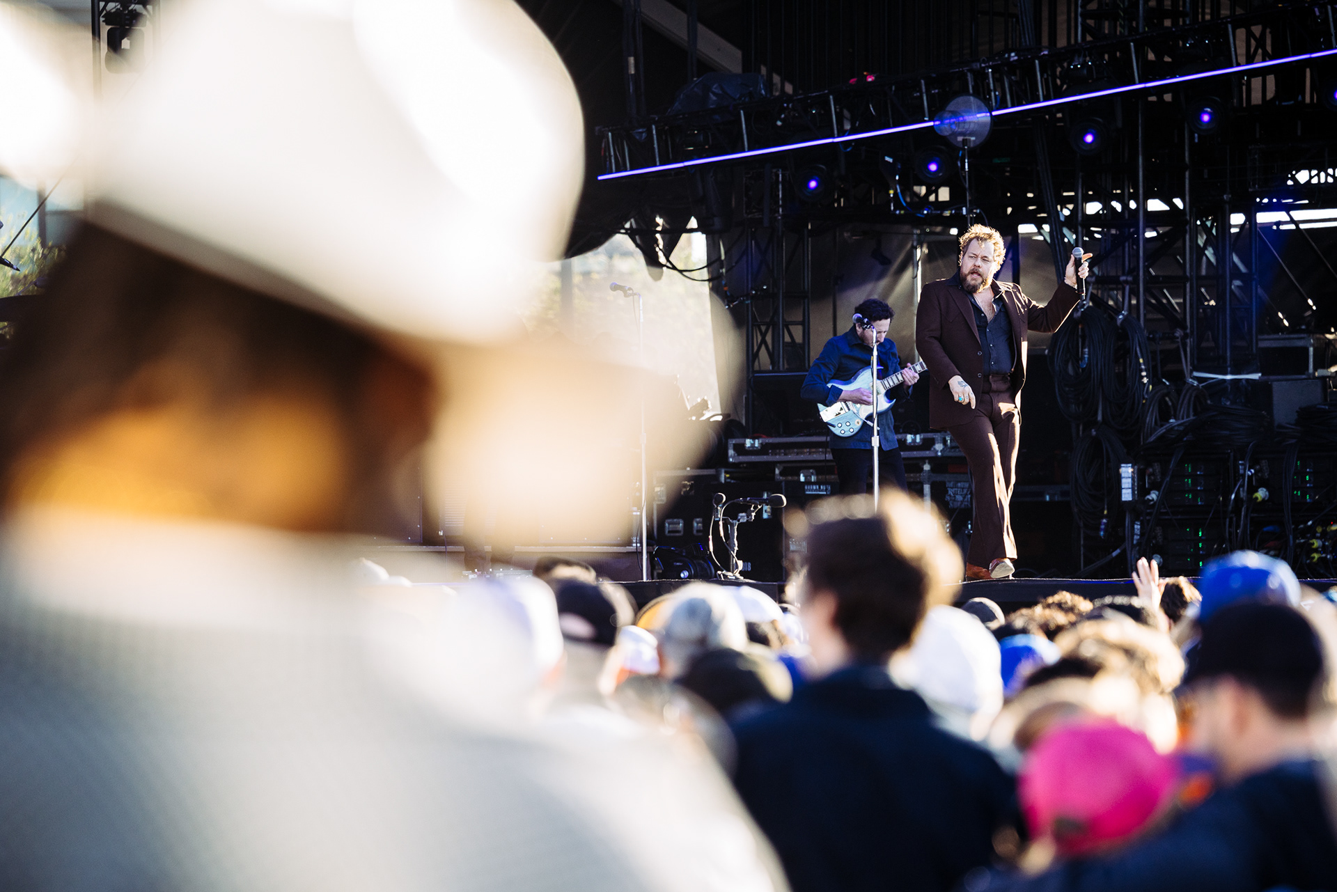 fan in a cowboy hat watching a band on stage at a Texas music festival, photographed by Chris Stokes