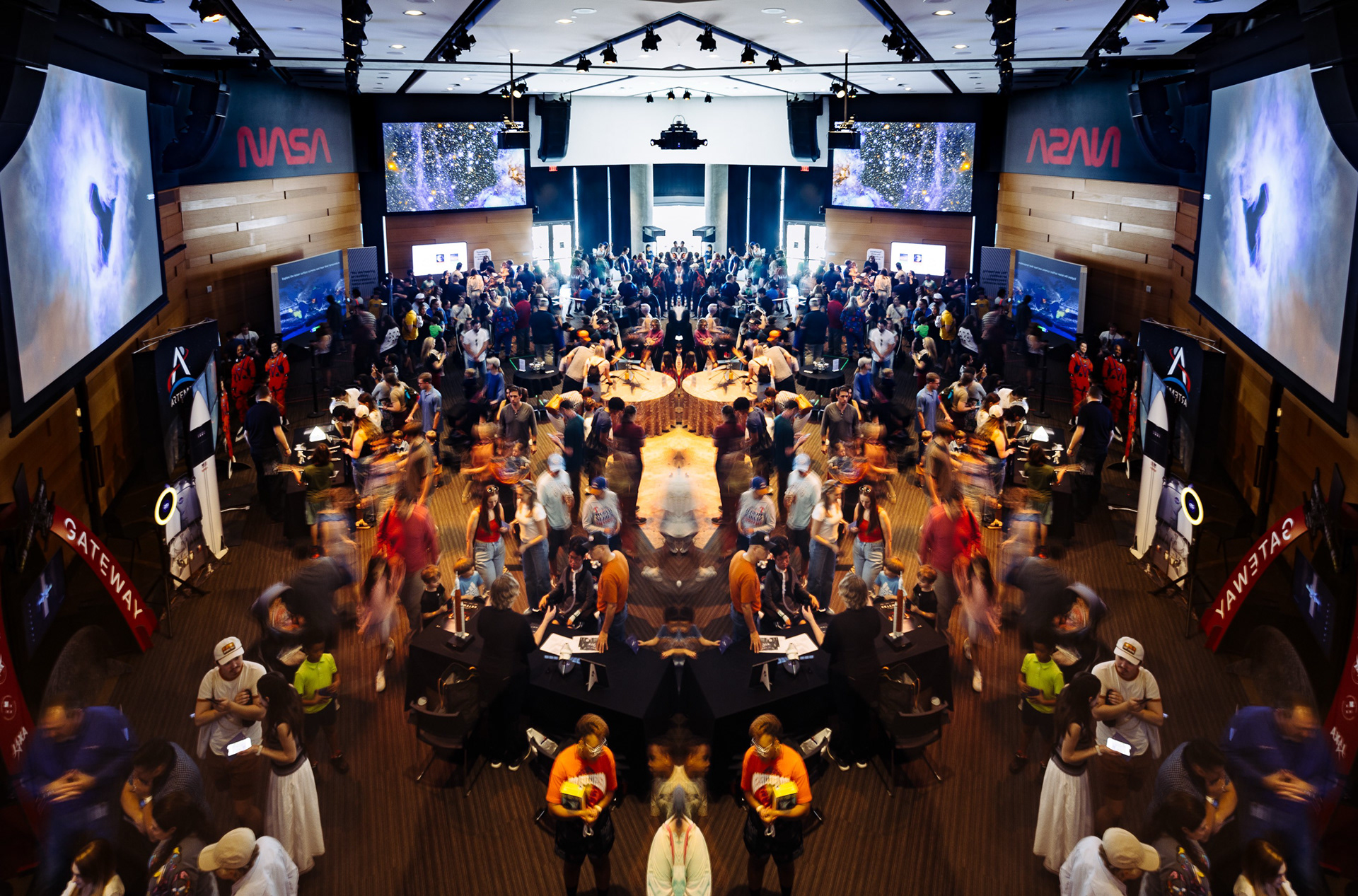 Crowded event hall with large video screens