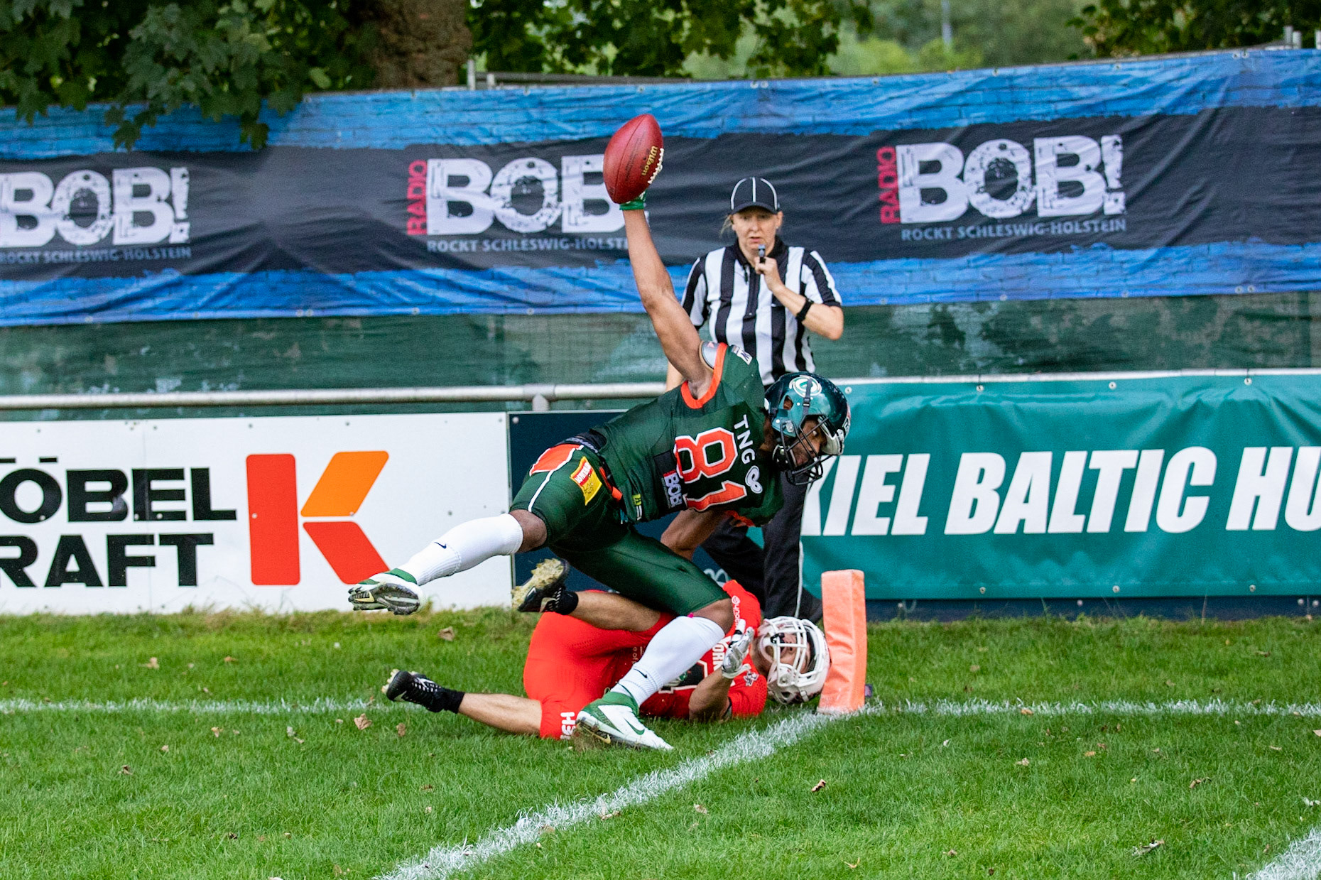 81 Kwame Ofori (grün) gegen 24 Paul Baron (rot) im Spiel der Kiel Baltic Hurricanes (grün) gegen die Braunschweig New Yorker Lions (rot) am 03.08.19 im Kilia Stadion in Kiel