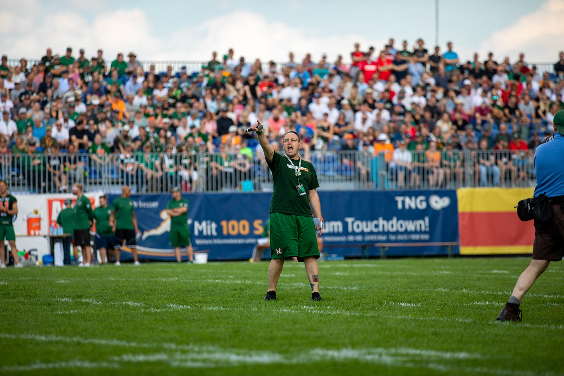 Kurzer Technik-Ausfall beim Einlaufen der Mannschaften störte den Stadionsprecher nicht. Er brüllte einfach. im Spiel der Kiel Baltic Hurricanes (grün) gegen die Braunschweig New Yorker Lions (rot) am 03.08.19 im Kilia Stadion in Kiel