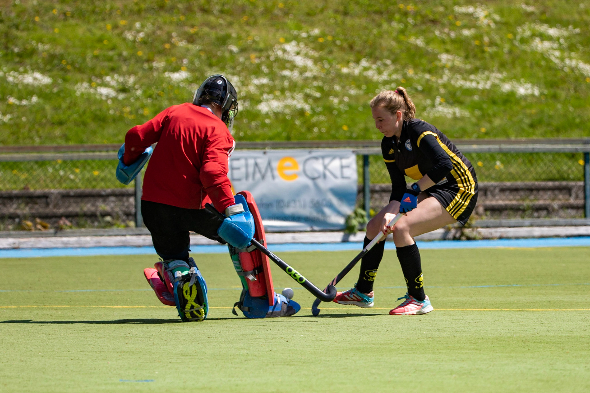 Hannah Schwerdtfeger (schwarz) gegen Torfrau Christina Wittrin (weiß) im Spiel der Damen Hockey Oberliga zwischen dem 1. Kieler HTC (schwarz) und dem Rahlstedter HTC (weiß) am 12.05.19 auf der Kunstrasenanlage des 1. Kieler HTC in Kiel