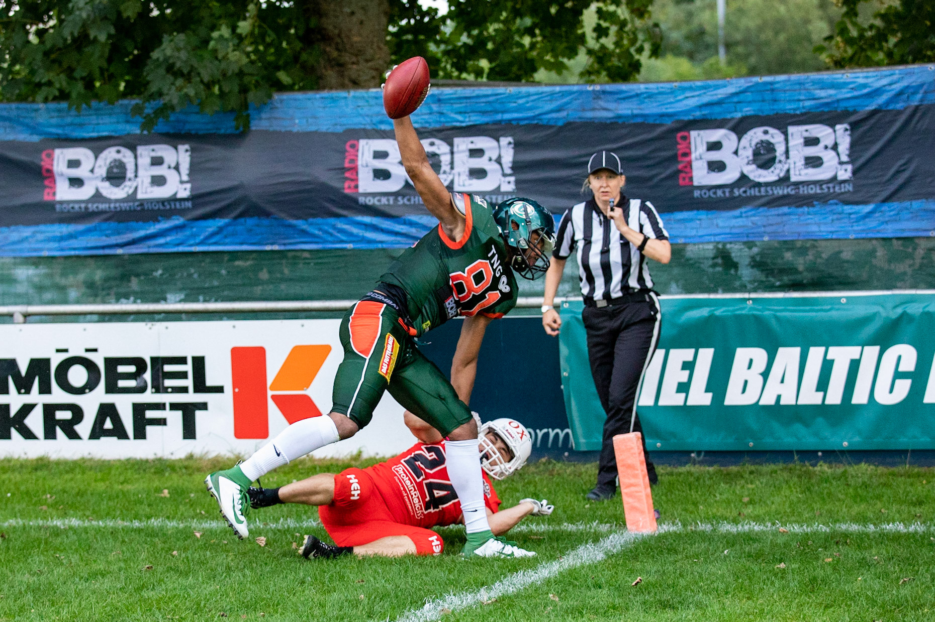 81 Kwame Ofori (grün) gegen 24 Paul Baron (rot) im Spiel der Kiel Baltic Hurricanes (grün) gegen die Braunschweig New Yorker Lions (rot) am 03.08.19 im Kilia Stadion in Kiel