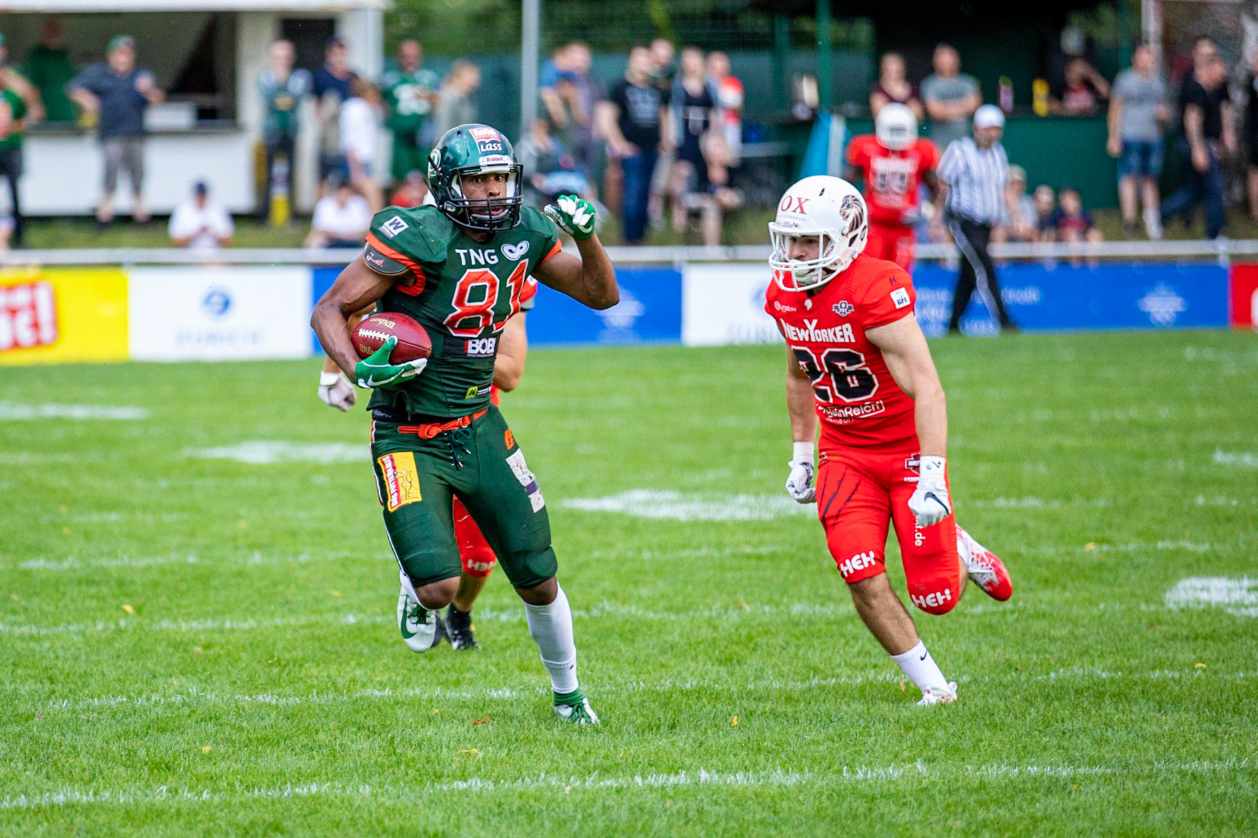 81 Kwame Ofori (grün) gegen 26 Paul Calamita (rot) im Spiel der Kiel Baltic Hurricanes (grün) gegen die Braunschweig New Yorker Lions (rot) am 03.08.19 im Kilia Stadion in Kiel