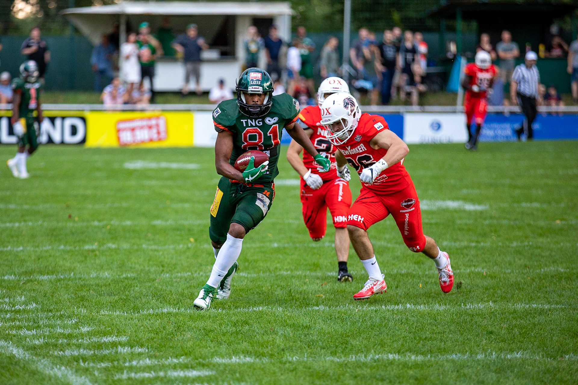 81 Kwame Ofori (grün) gegen 26 Paul Calamita (rot) im Spiel der Kiel Baltic Hurricanes (grün) gegen die Braunschweig New Yorker Lions (rot) am 03.08.19 im Kilia Stadion in Kiel