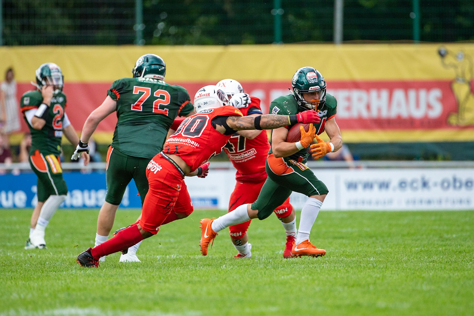 24 Fritjof Richter (grün) gegen 30 Jamaal White (rot) im Spiel der Kiel Baltic Hurricanes (grün) gegen die Braunschweig New Yorker Lions (rot) am 03.08.19 im Kilia Stadion in Kiel