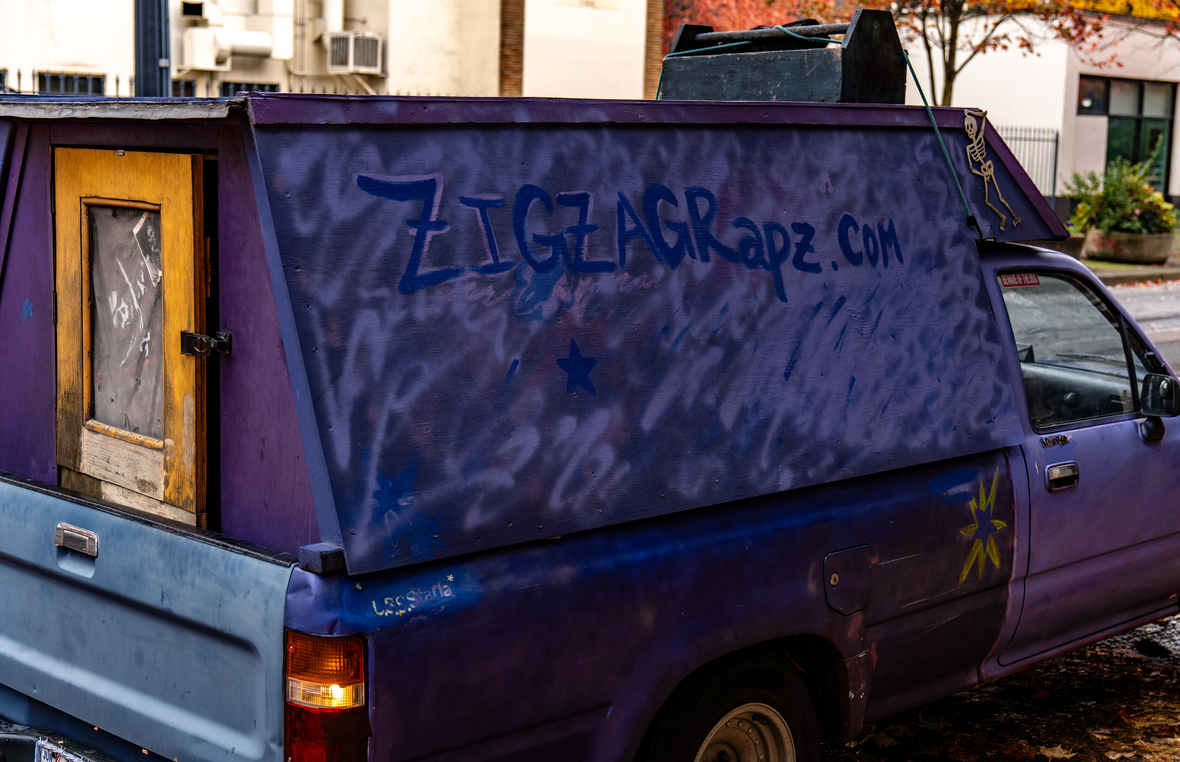 Aspiring poet, actor, acrobat, and rapper Zigzag Rhae advertises their website on their haphazardly spray-painted truck. Moments like this happen frequently in Portland.