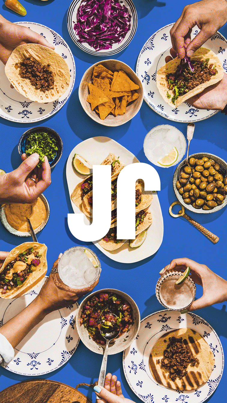 Animated gif of the JoyRun icon in the foreground and people building tacos from a buffet of ingredients in the background. (designs by Kat Vochoska).