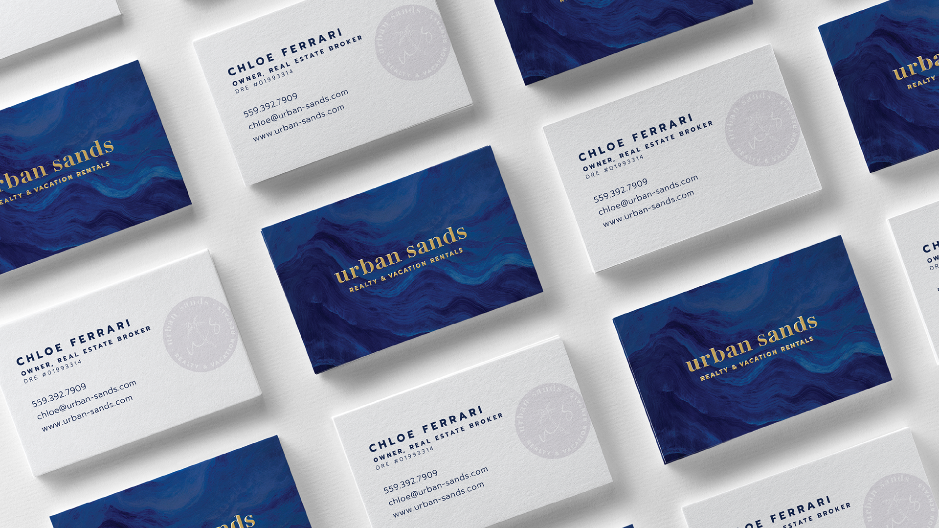 Photo of the business card front and back featuring the custom ocean texture, logo, and stamp (designs by Kat Vochoska).