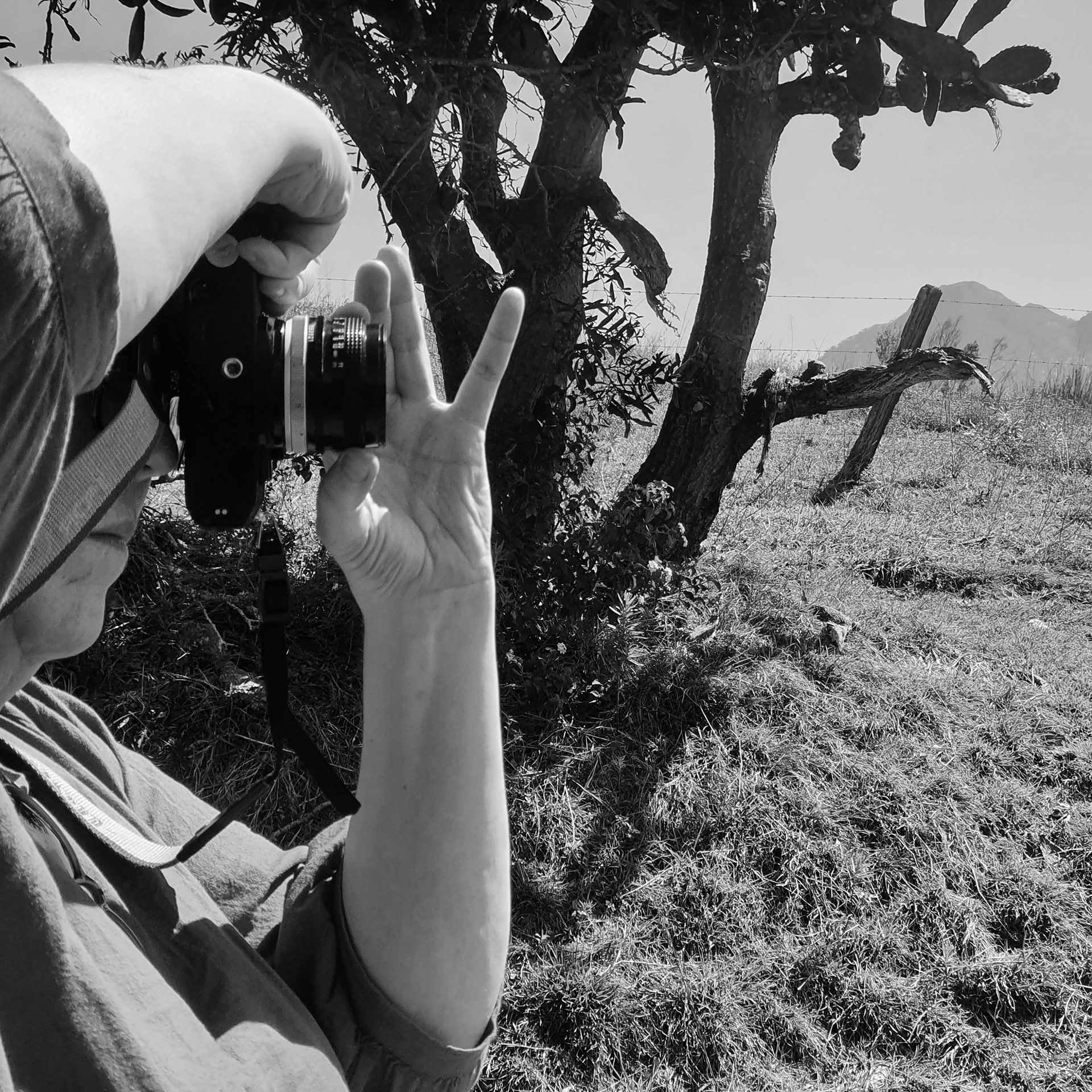SAM CREYTON, 2021. IMAGE DESCRIPTION: PROFILE SHOT OF PERSON TAKING PHOTO IN BLACK AND WHITE
