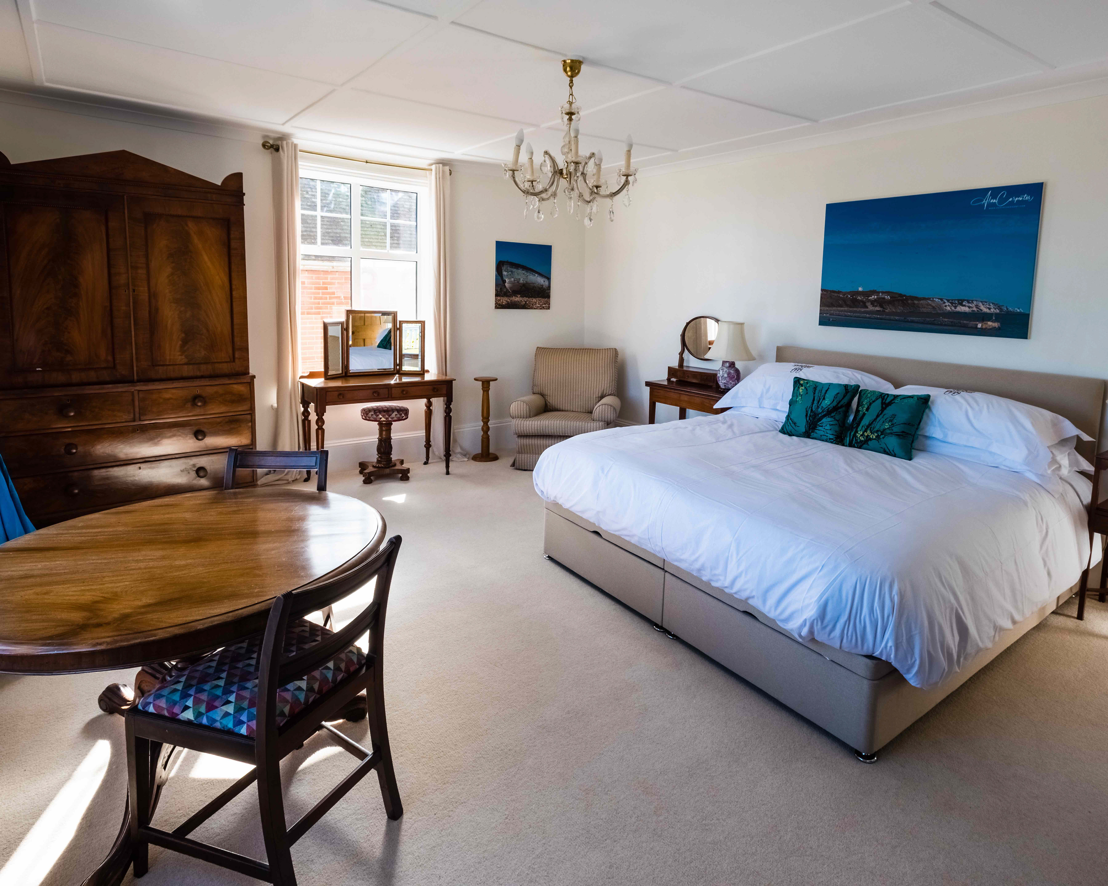 Spacious king bedroom with coastal artwork and morning light