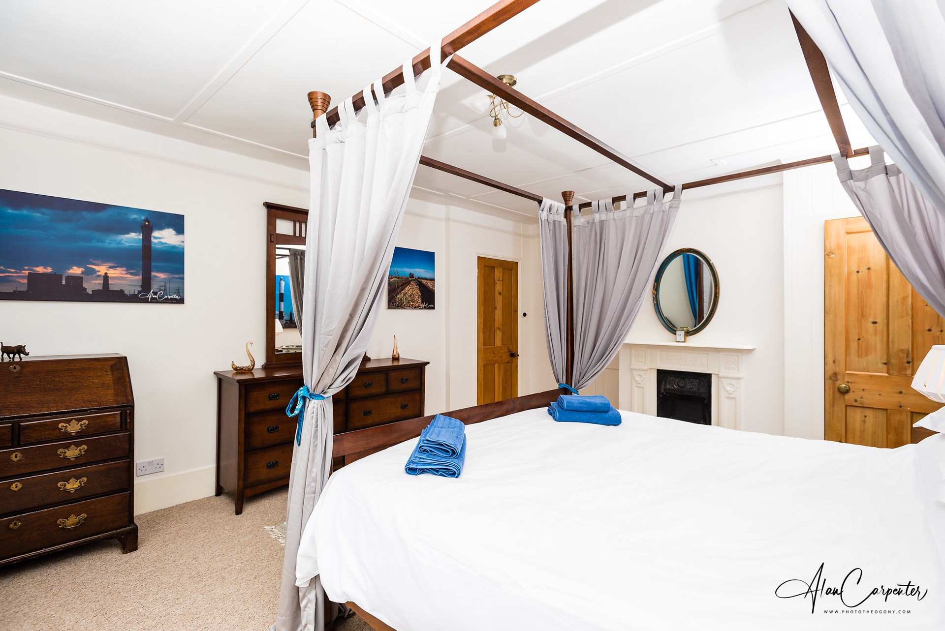 Elegant four-poster suite with antique furnishings and sea-inspired décor