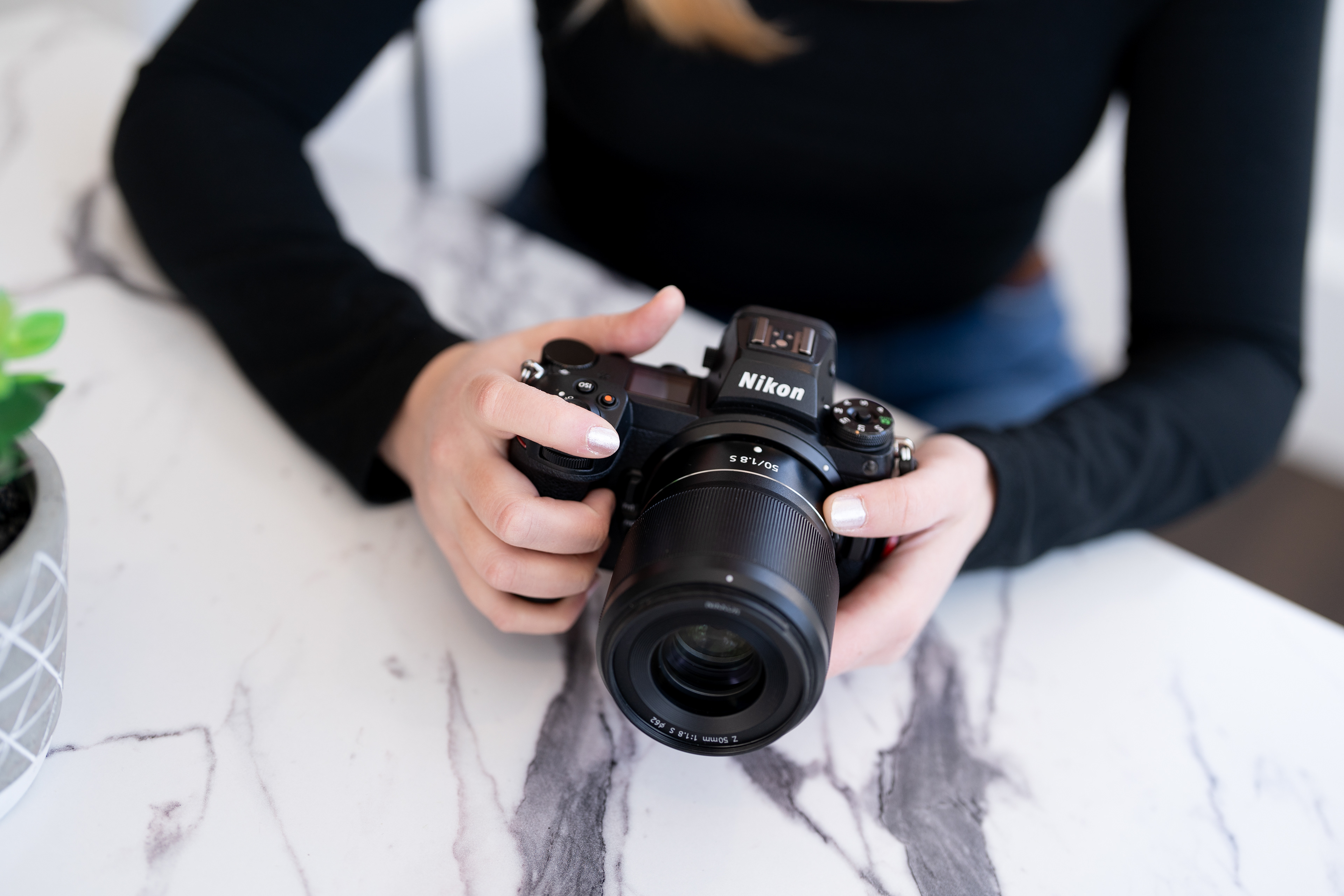 Photo of a lady holding a Nikon Camera