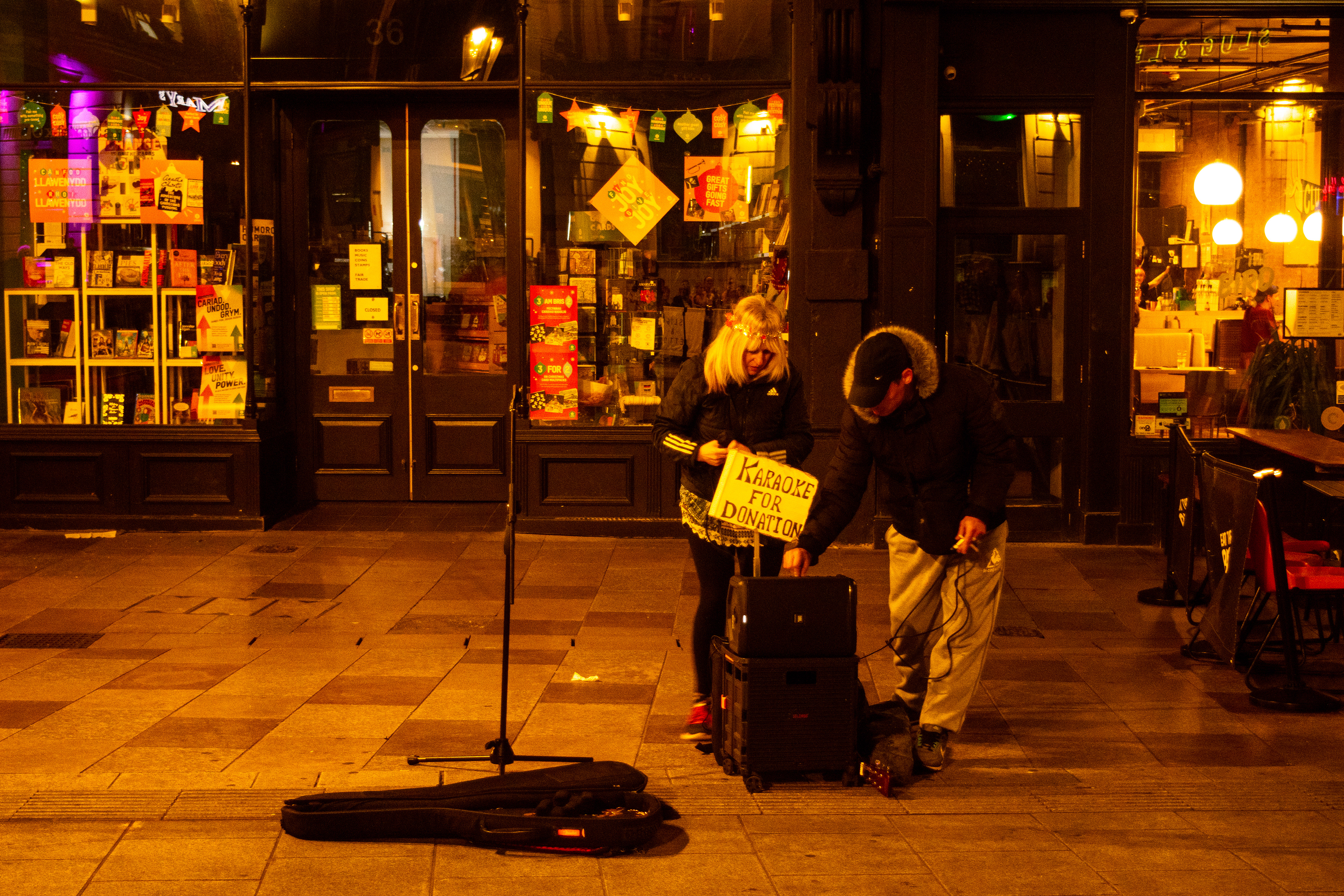 'Karaoke for Donation'. A man and a woman set up the karaoke machine on St Mary Street, Cardiff.