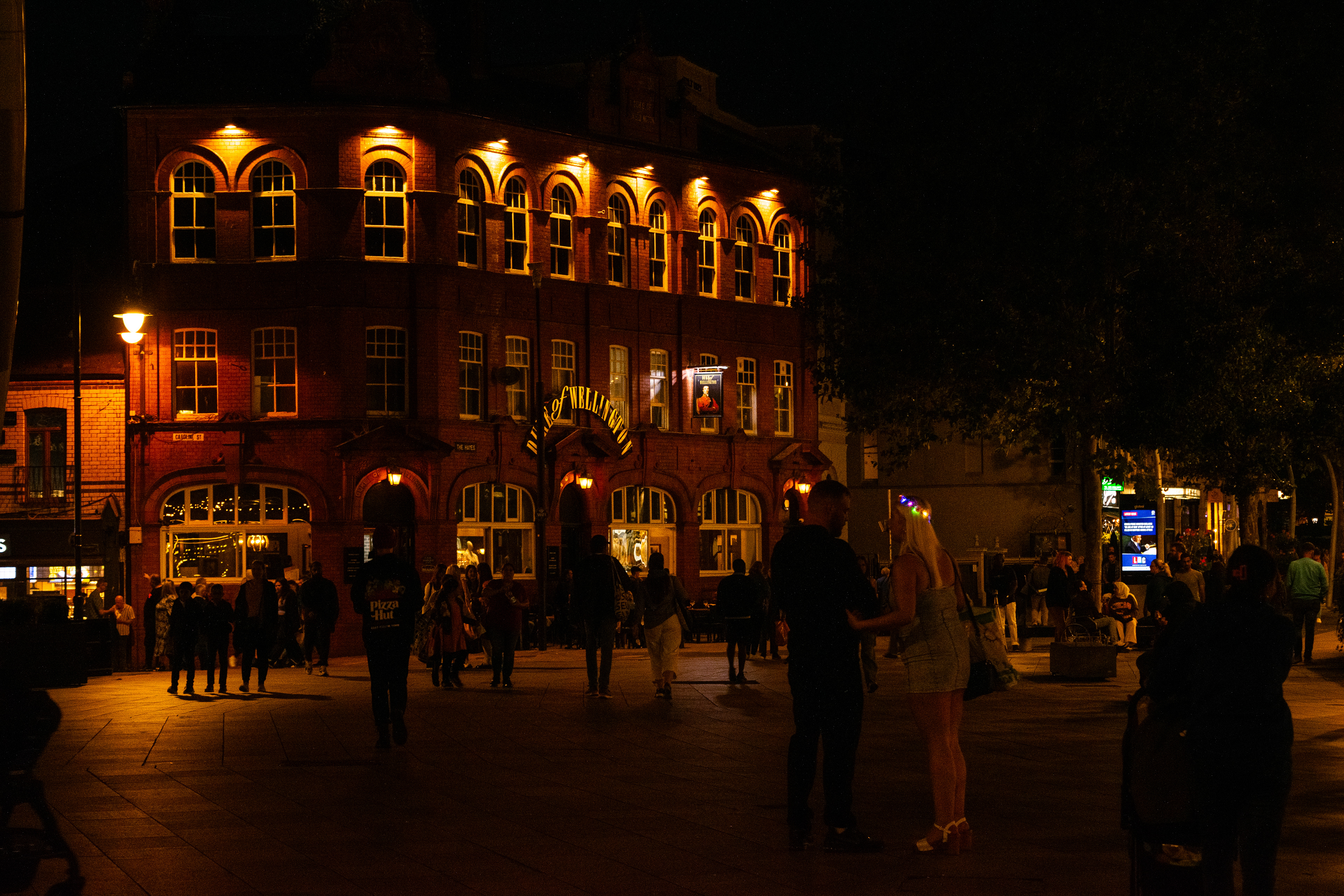 A woman holds her man's hand on a weekend night at Cardiff City Centre.