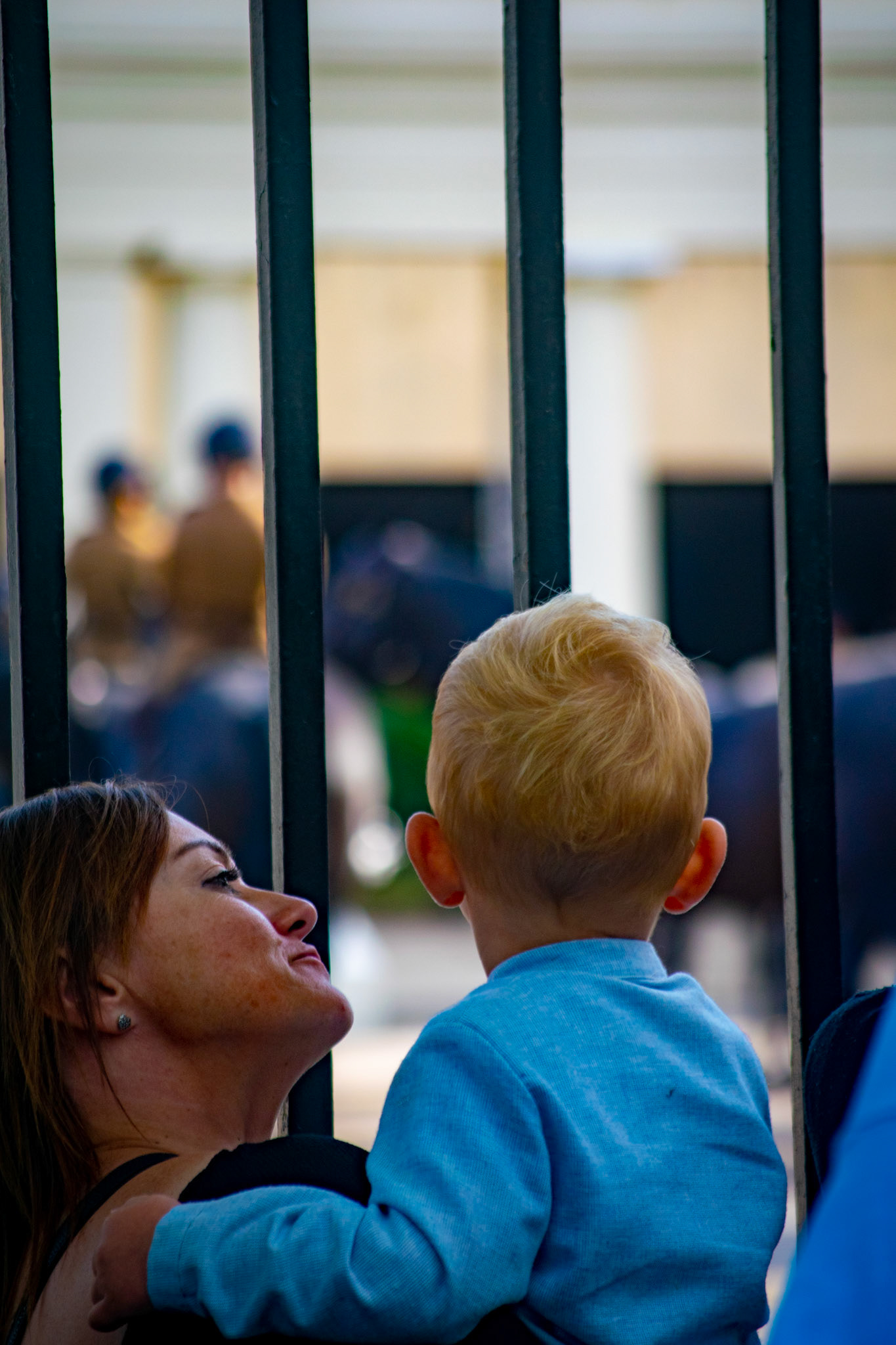 A mother looks at her son as he is busy watching the horses in the Wellington Barracks.