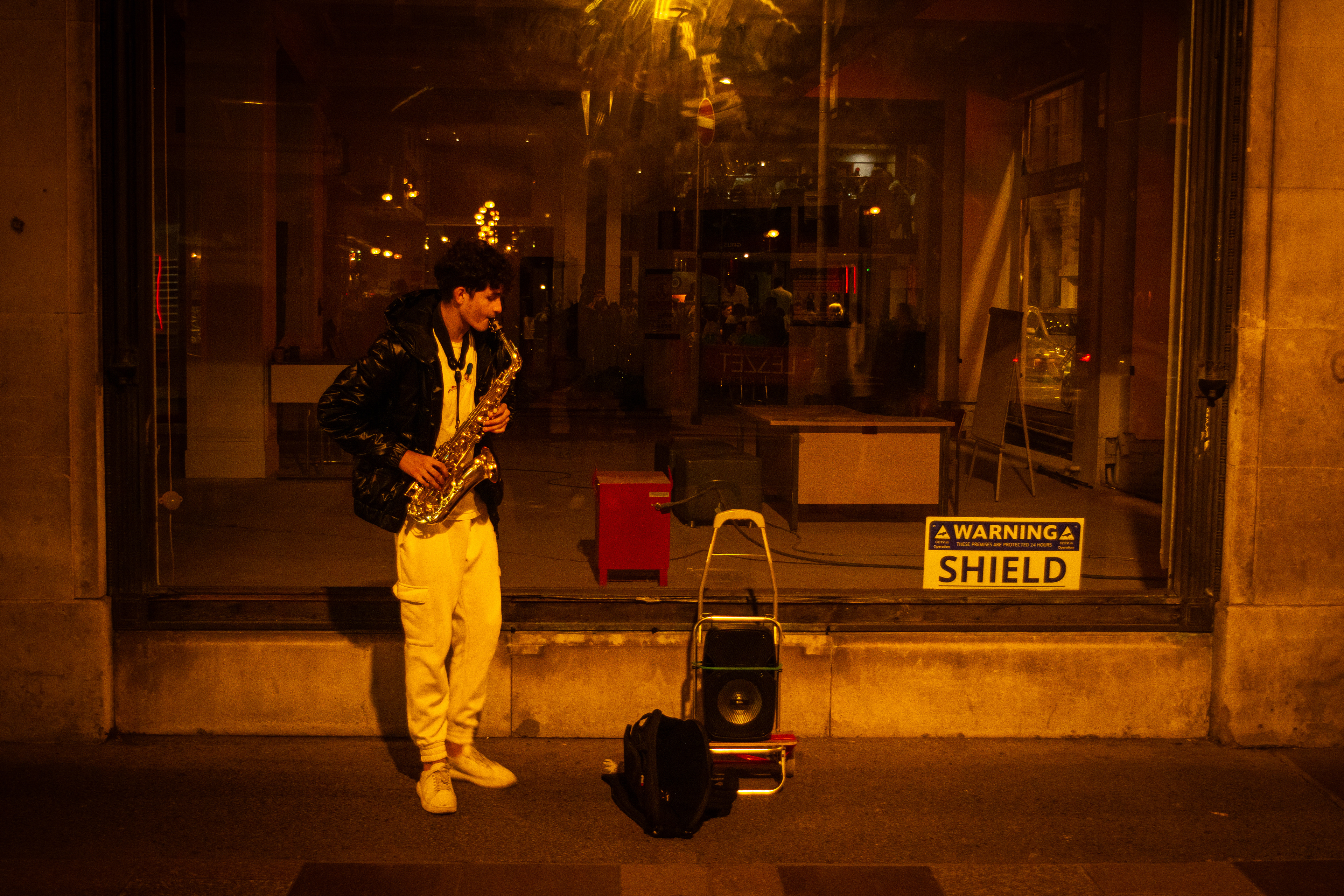 'Busking' A boy plays his saxophone. 