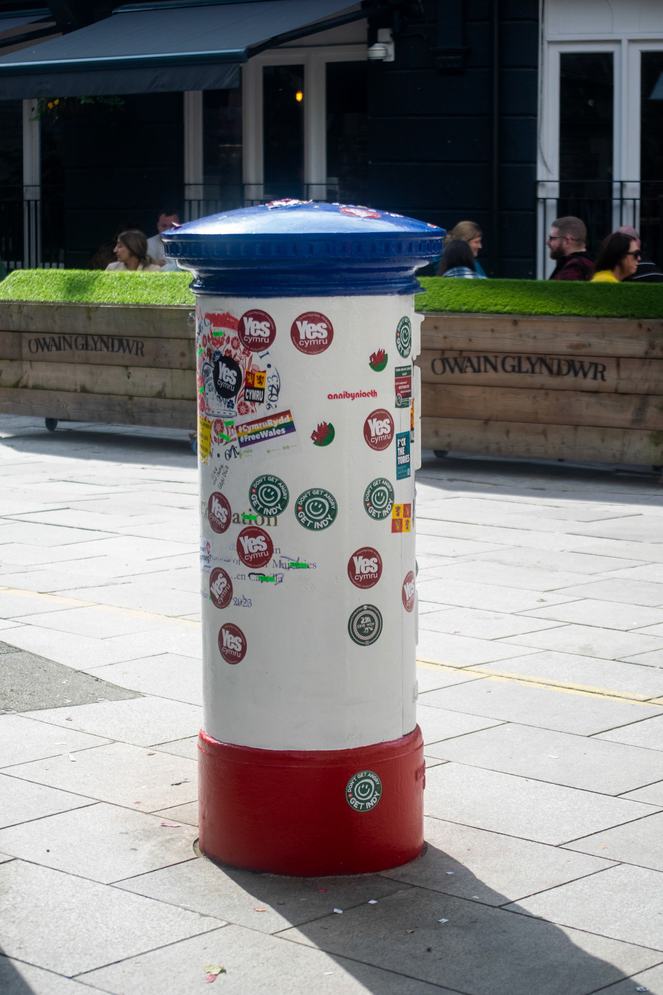 The red, white and blue Royal Mail postbox unvieled in the honor of King' coronation was plastered with various Welsh Independence stickers.