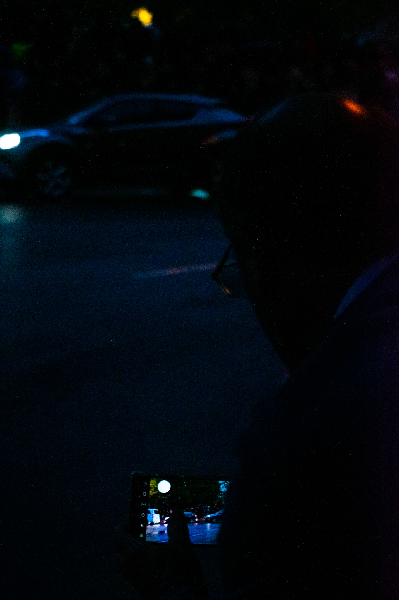 A man clicks a picture of the crowd on his phone.