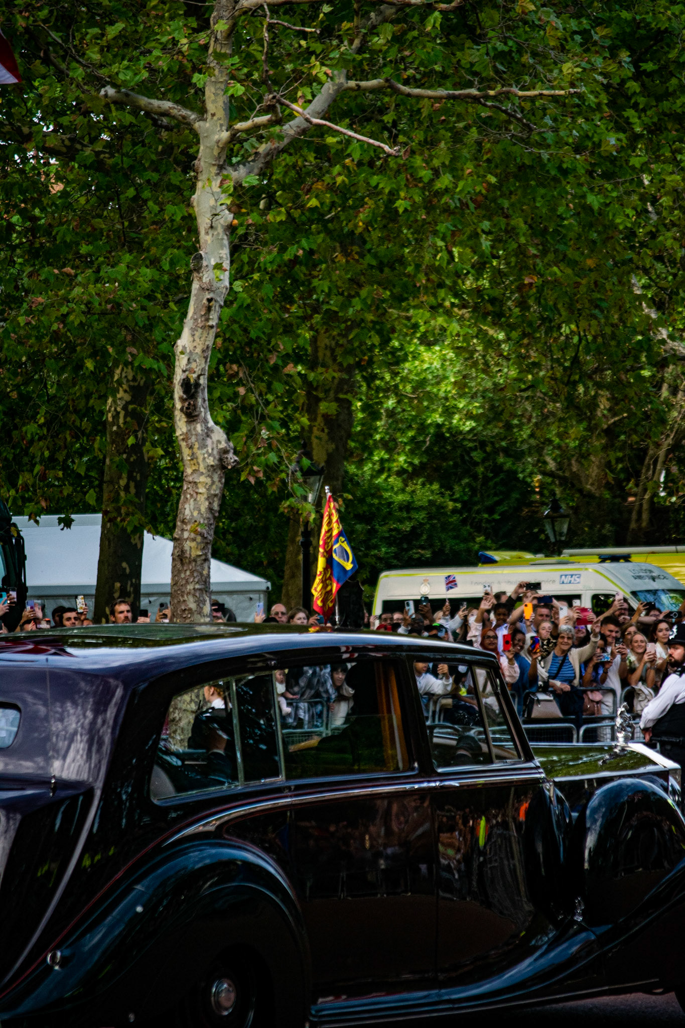 The crowd waves to King Charles III inside a 1950 Rolls-Royce Phantom IV state limousine as the royal convoy passes. This car was built 72 years ago for Queen Elizabeth when she was still a princess. Originally it was in Edinburgh green colours with several modifications made by the Duke of Edinburgh, Prince Philip, as it was their private car. After Princess Elizabeth succeeded on the throne, this became her official state car, repainted in the sovereign’s colour scheme of royal claret and black.