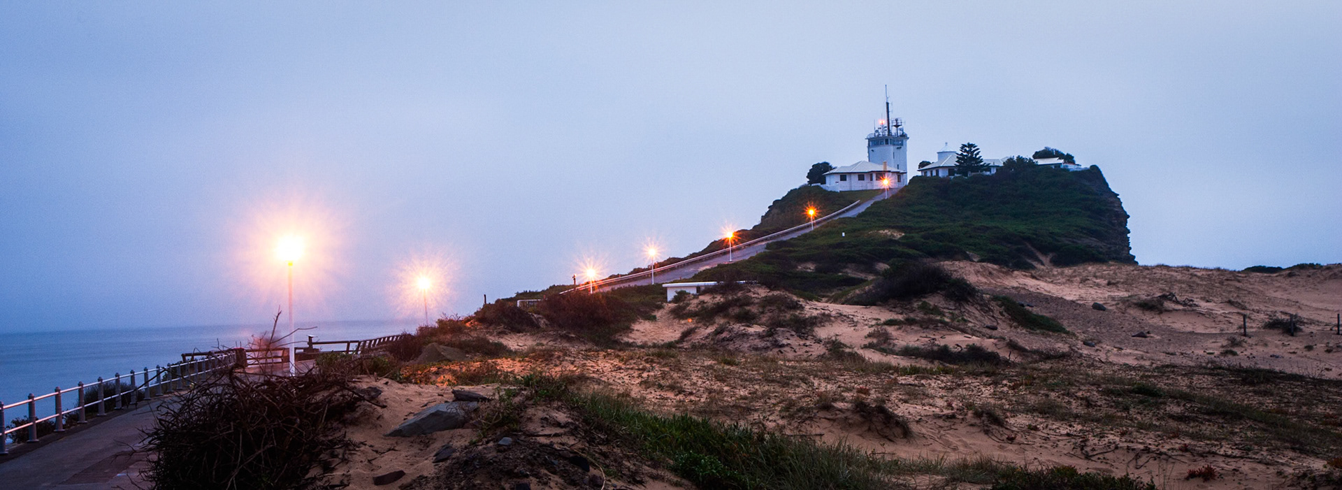 An early morning shot of the road and lights leading up to the lighhouse at Nobby's beach, Newcastle
