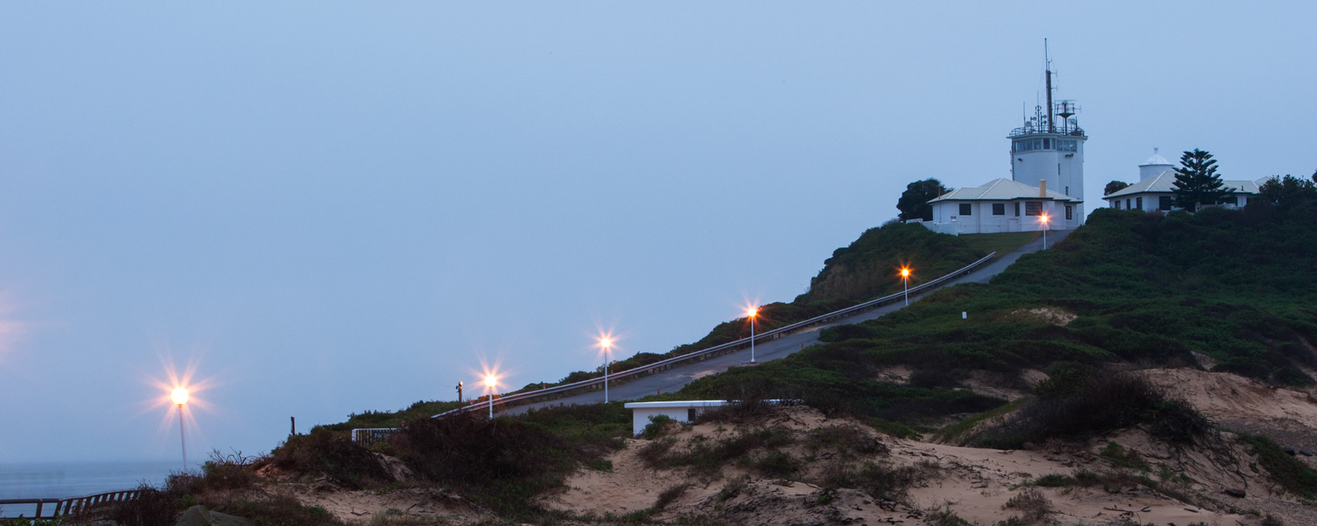 An early morning shot of the road and lights leading up to the lighhouse at Nobby's beach, Newcastle