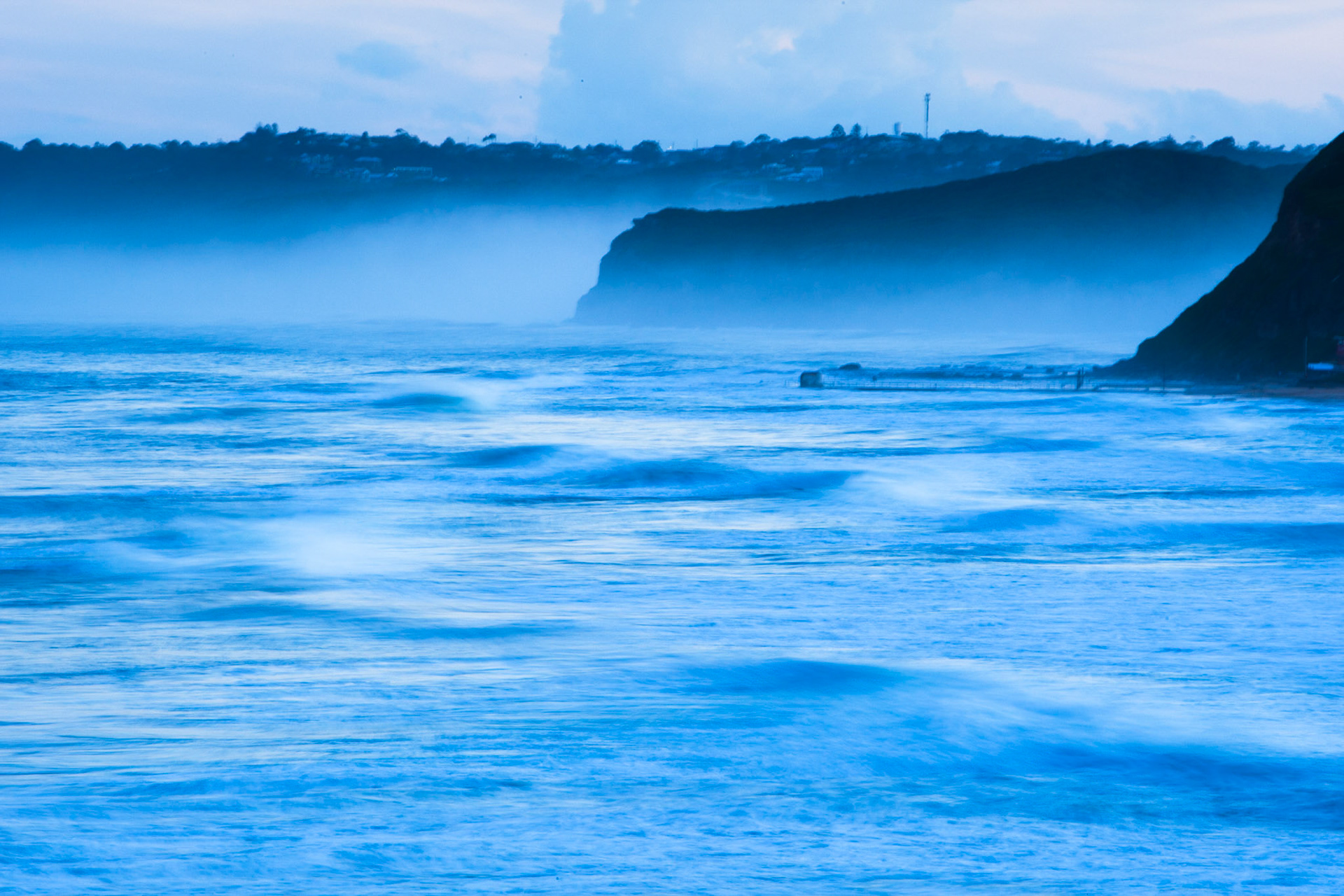Sunset at Newcastle beach, New South Wales, Australia, showing soft seas and mist.
