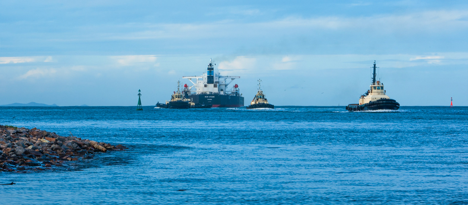 Three tugs guided New Stage, a bulk carrier, down the Hudson river to the open sea. Newcastle.