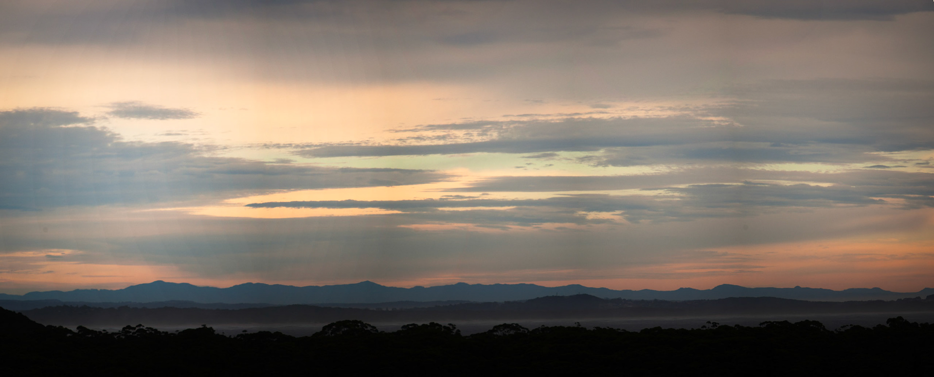 Late afternoon balcony view of pink sky and tiered mountain ranges, Bluey's Beach.