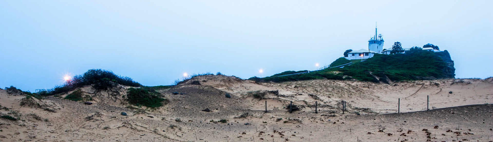 An early morning shot of the road and lights leading up to the lighhouse at Nobby's beach, Newcastle