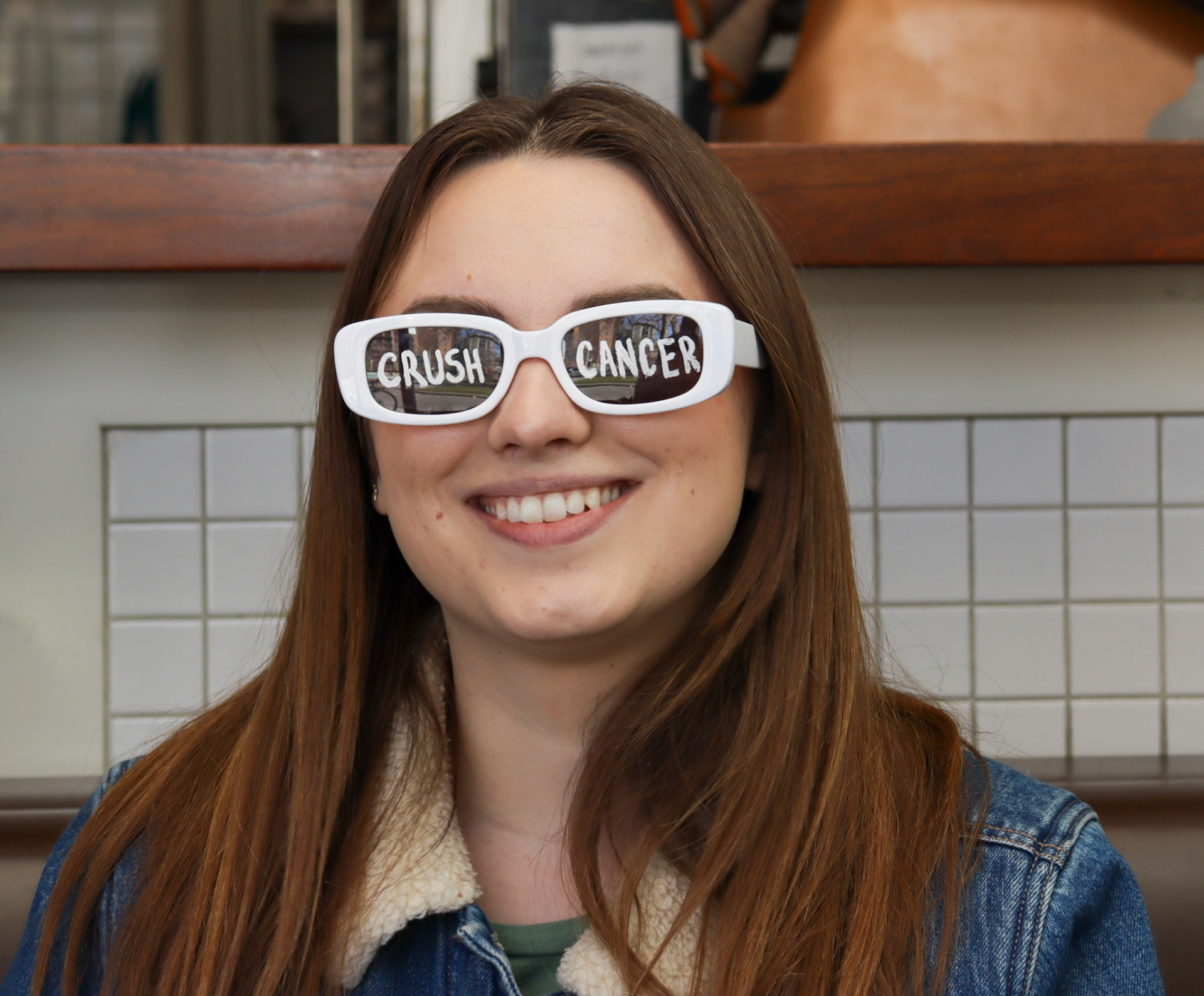 Lauren Anderson taking the "crush cancer" glasses for a spin on April 18, 2024 in Calgary, Alberta. Photo by Jenna Willox