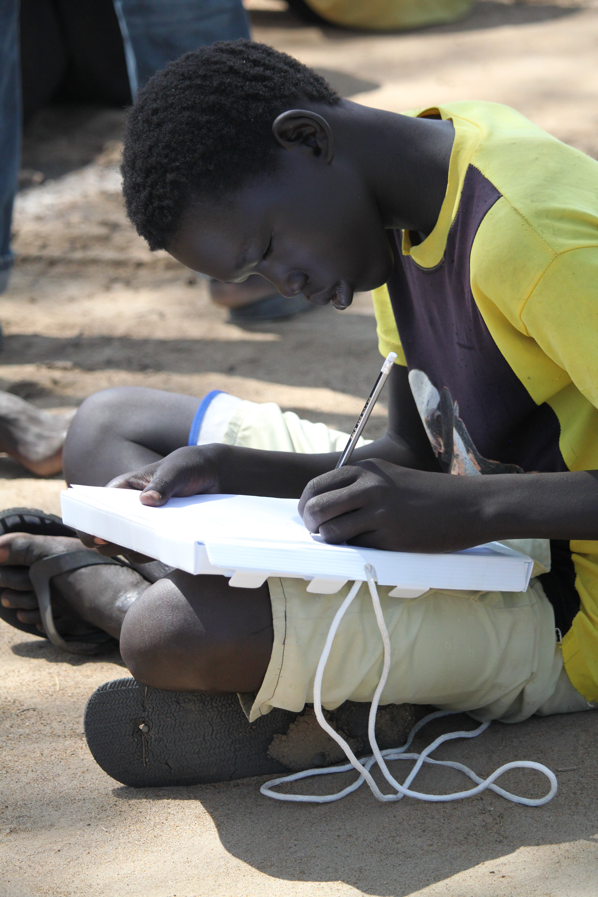 Young South Sudanese boy working on idea.