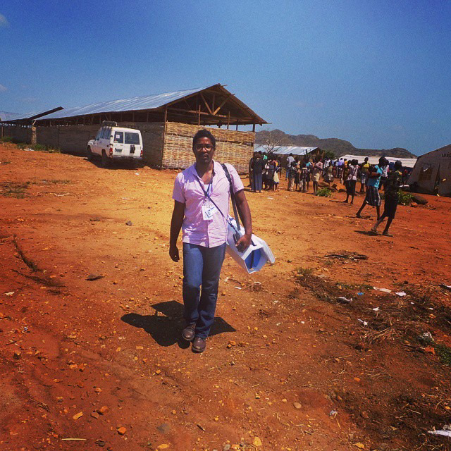 Jason Robinson walking through South Sudanese IDP camp with UNICEF's Adolescent Kit.