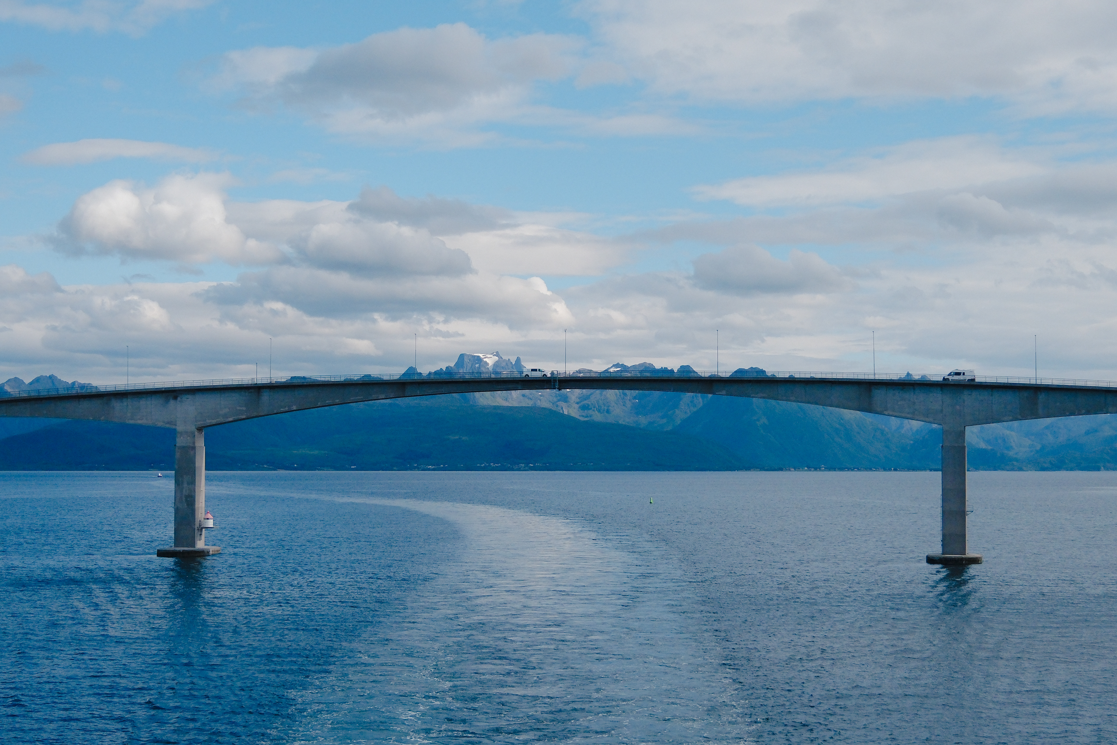 bridge in the north sea, view from the Hurtigruten boat in Norway with sea, bridge with cars and moutain in the background