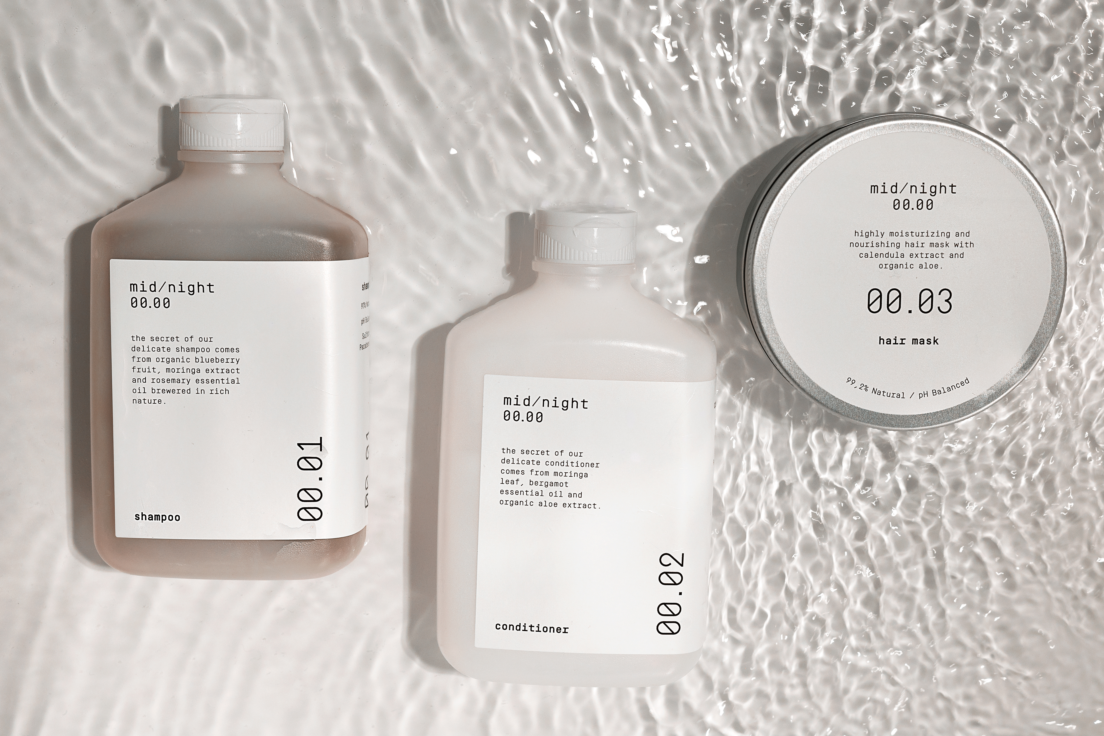 midnight hair products still life photography with background like water and little waves and the products foating