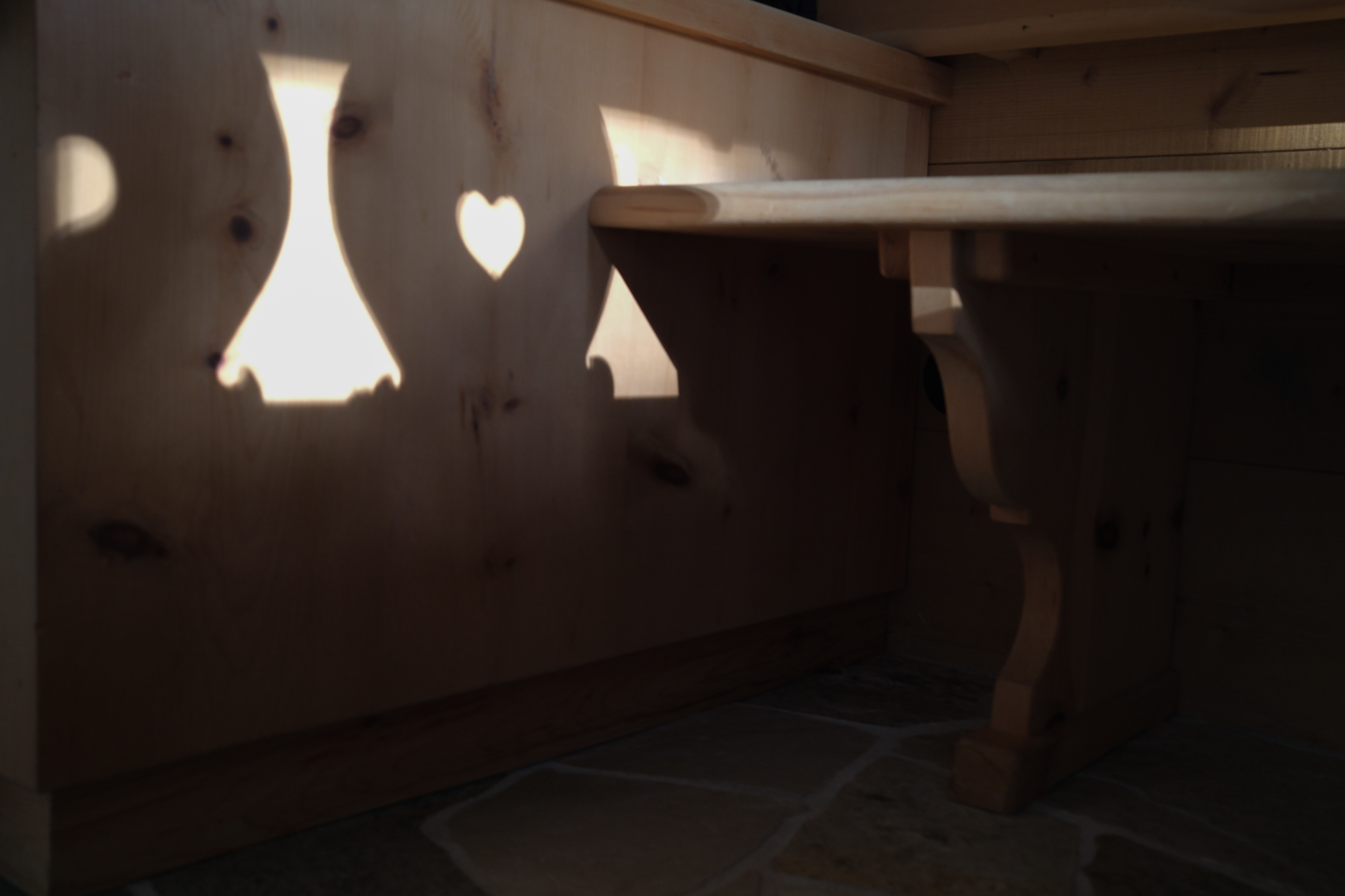 typical wooden Alps chairs with heart, shadows