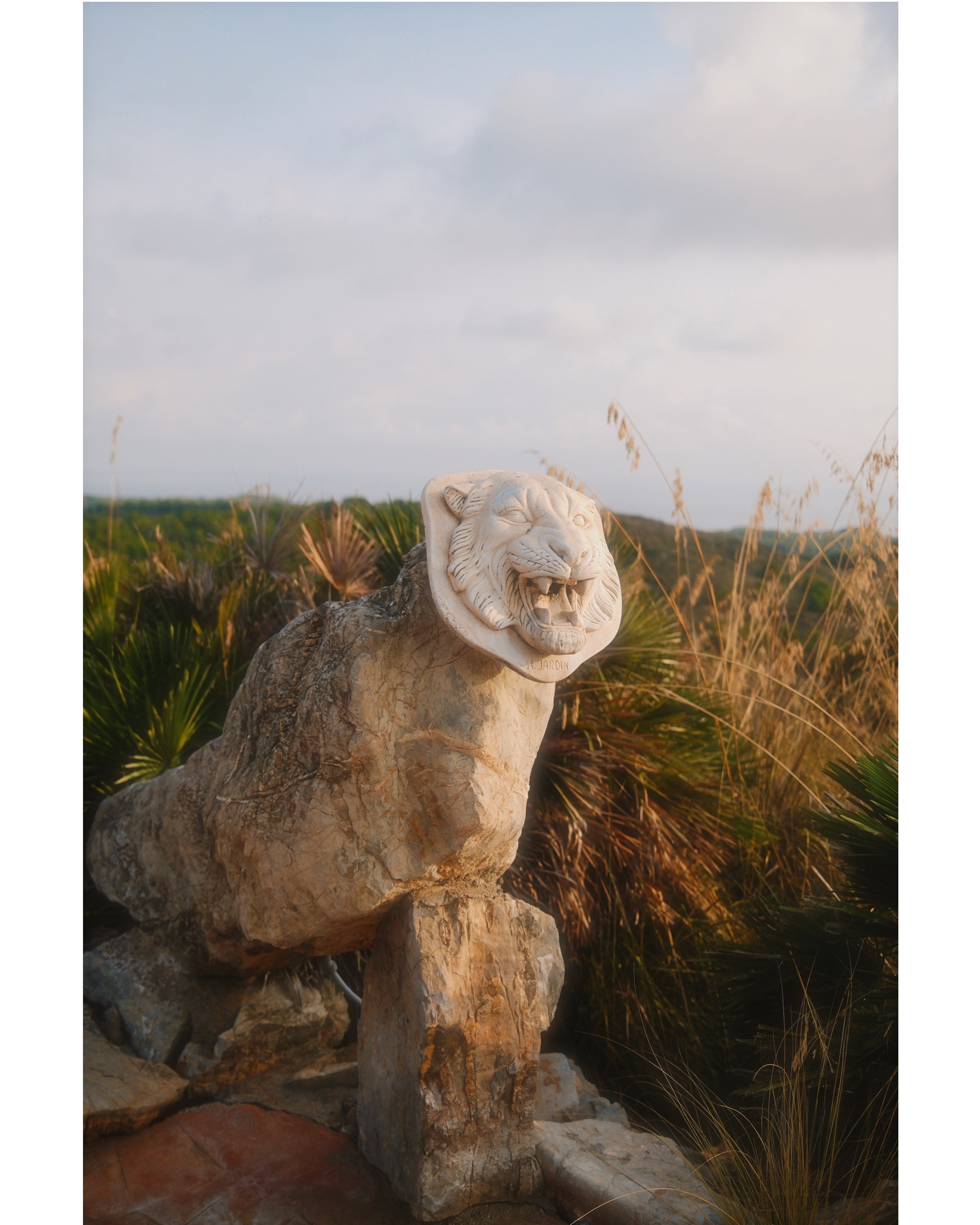 lion statue in mallorca with palms and grey sky