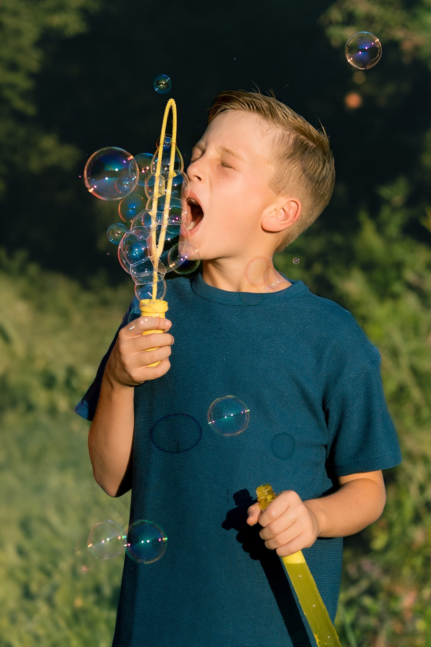 Boy playing with bubbles during an outdoor photo session