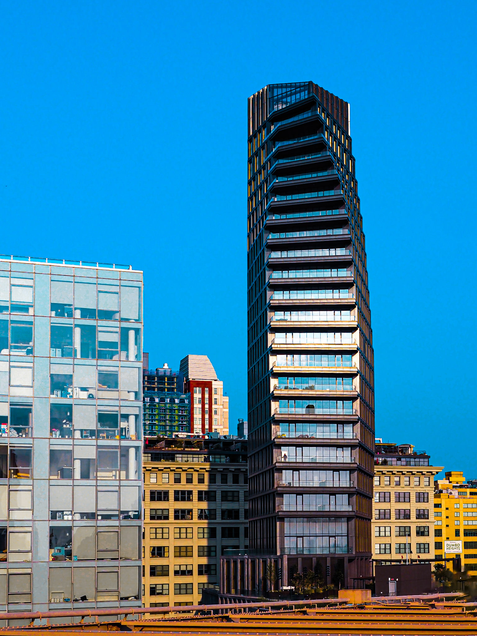 La modernidad se impone en altura, custodiada por un guardián felino de bronce.