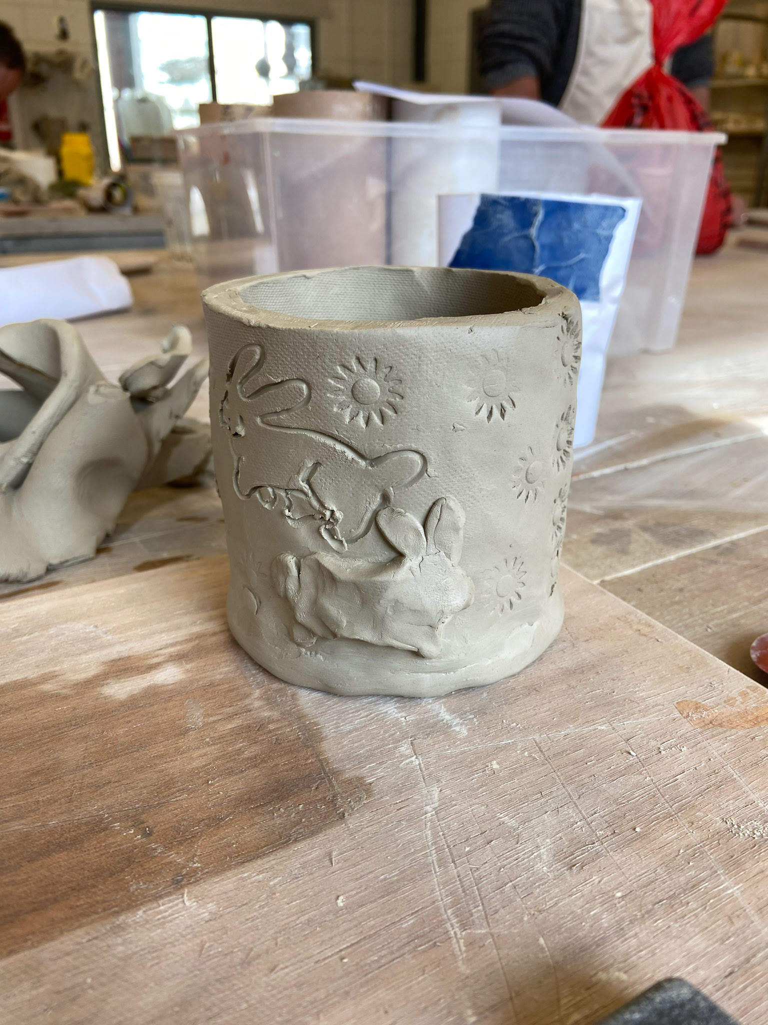 Carved bunnies and stuck on bunny models around the pot