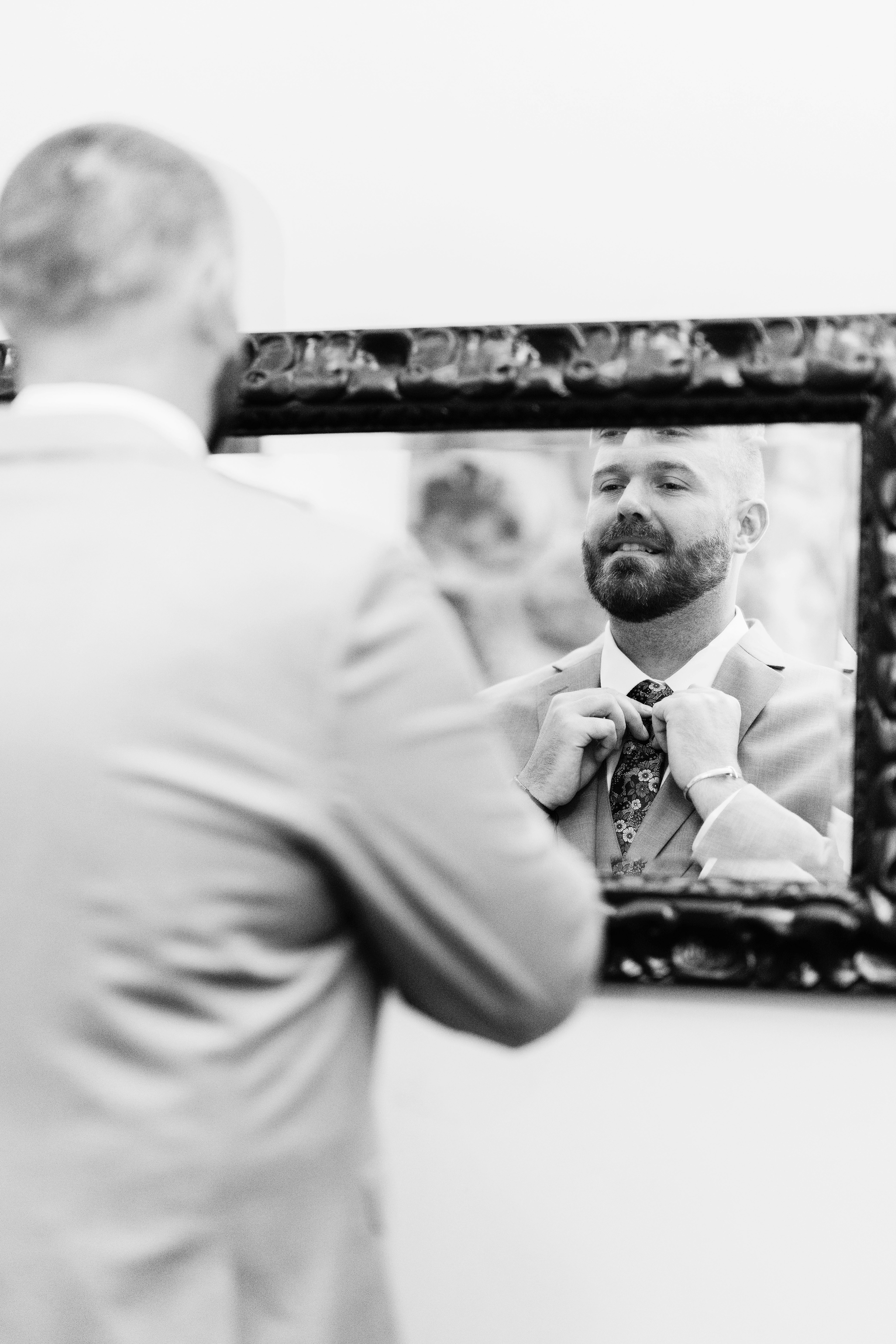 Candid groom portraits with mountain light streaming in — classic New Hampshire wedding morning at Indian Head Resort.