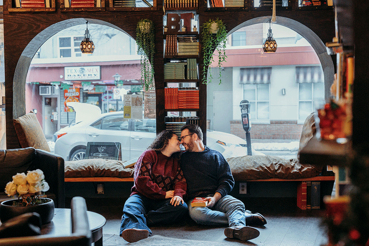 Non-traditional engagement photos in Southern New Hampshire, captured in a warm, intimate bookstore setting.