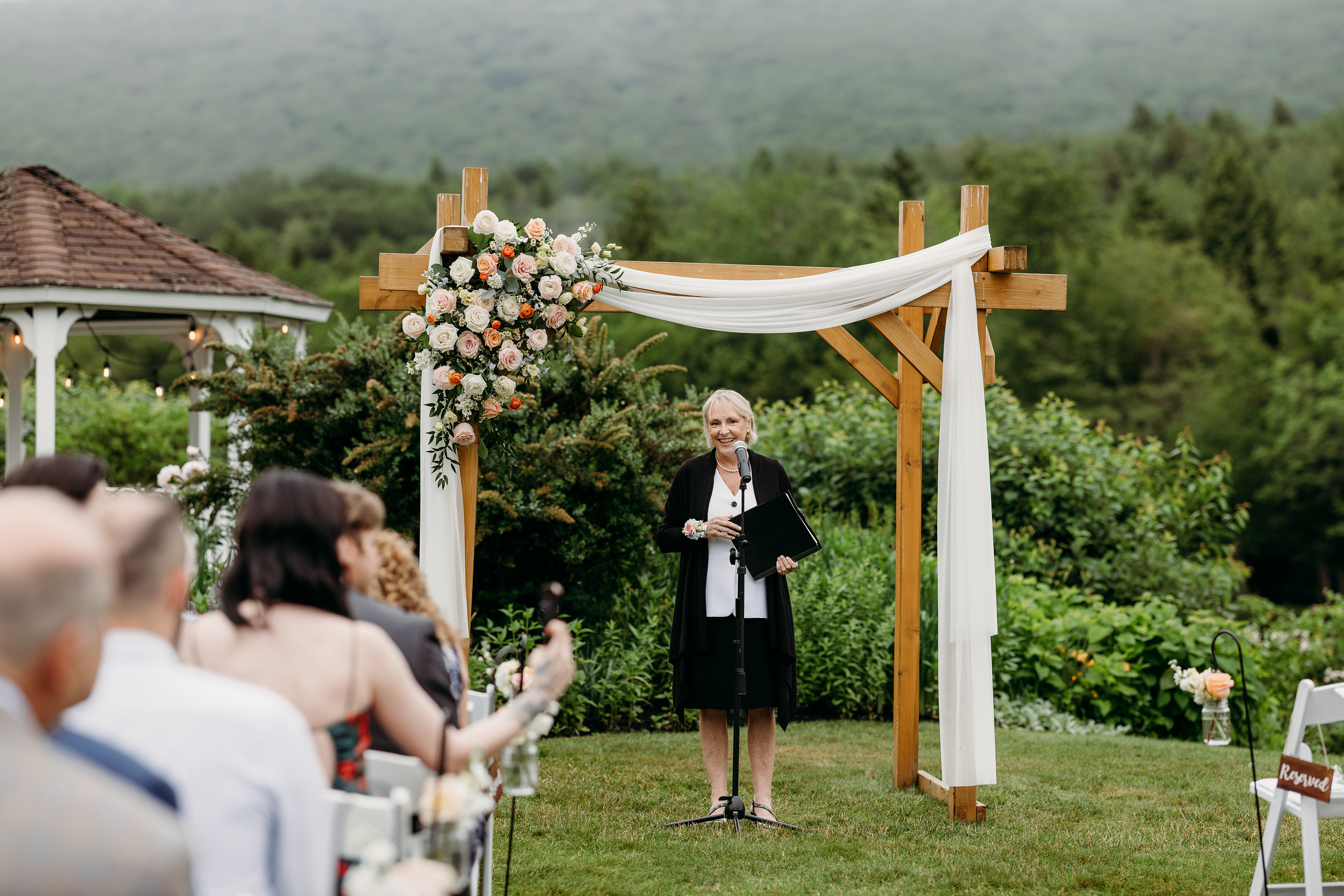 Ceremony arch kissed by fog and framed by the White Mountains — timeless New Hampshire romance.