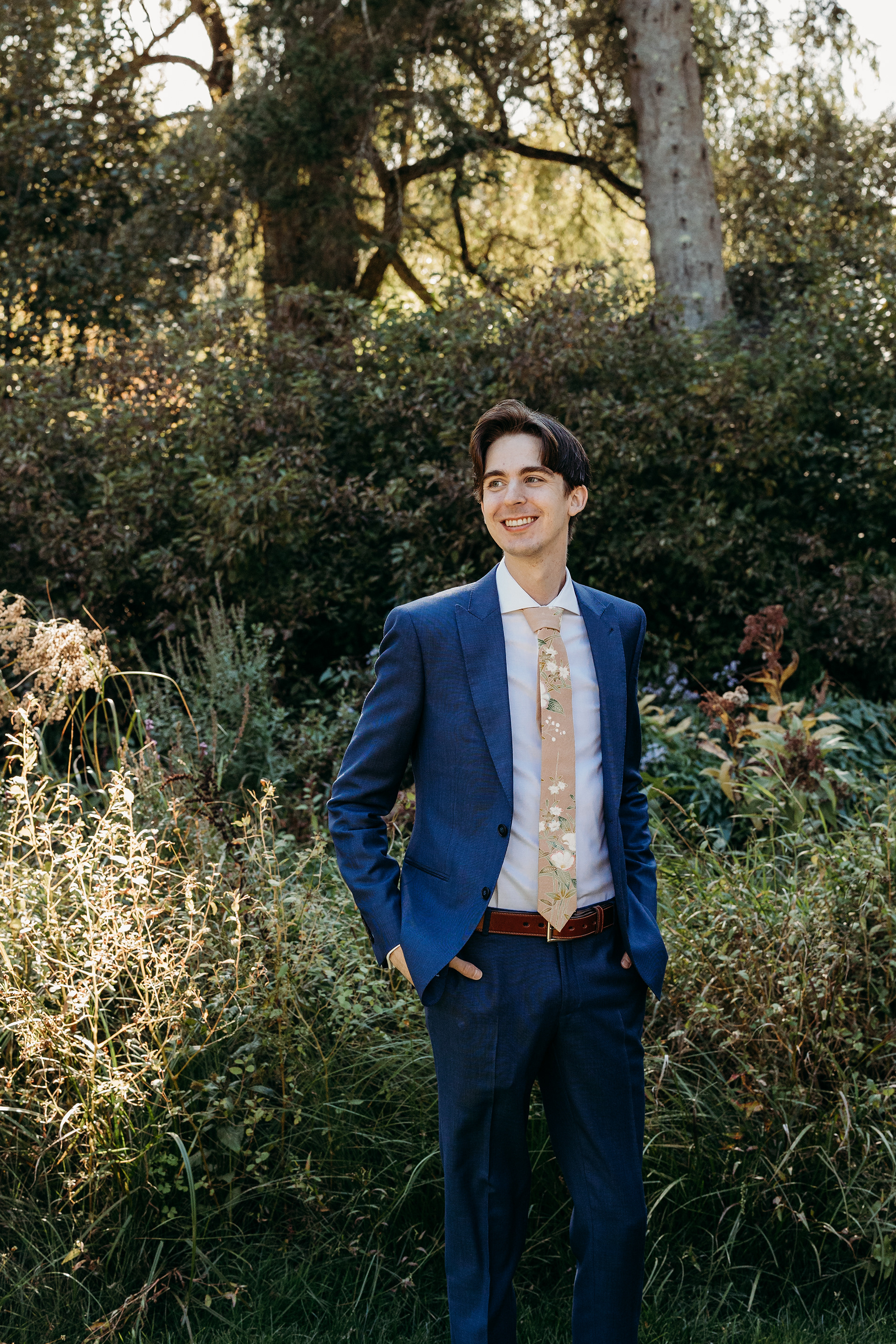 Nikolai posing by the Lakefield Cabin before the ceremony — calm, confident, and ready for his New Hampshire wedding by the lake.