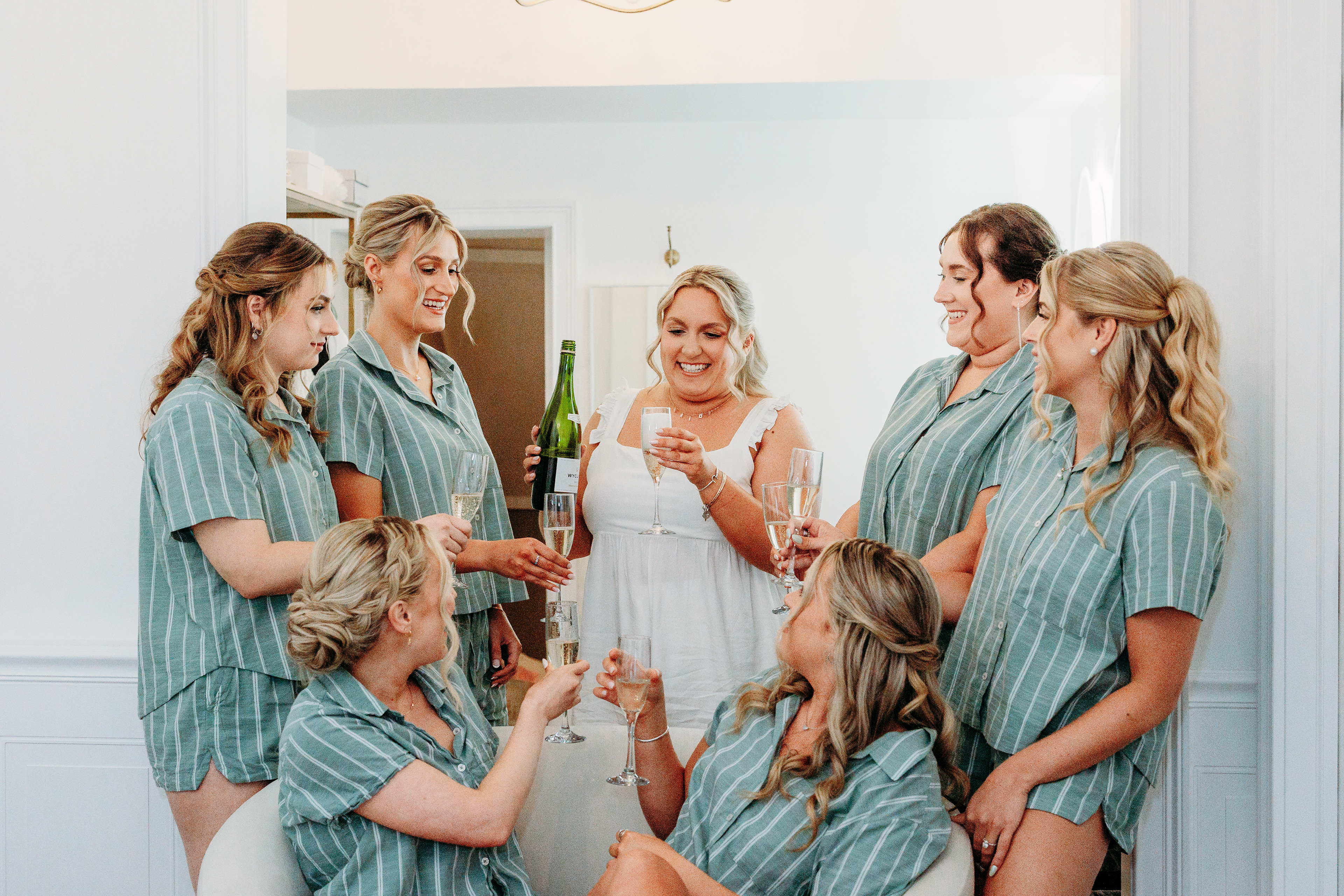 Bridesmaids toasting with mimosas before the first look — joyful moments at a White Mountains wedding.