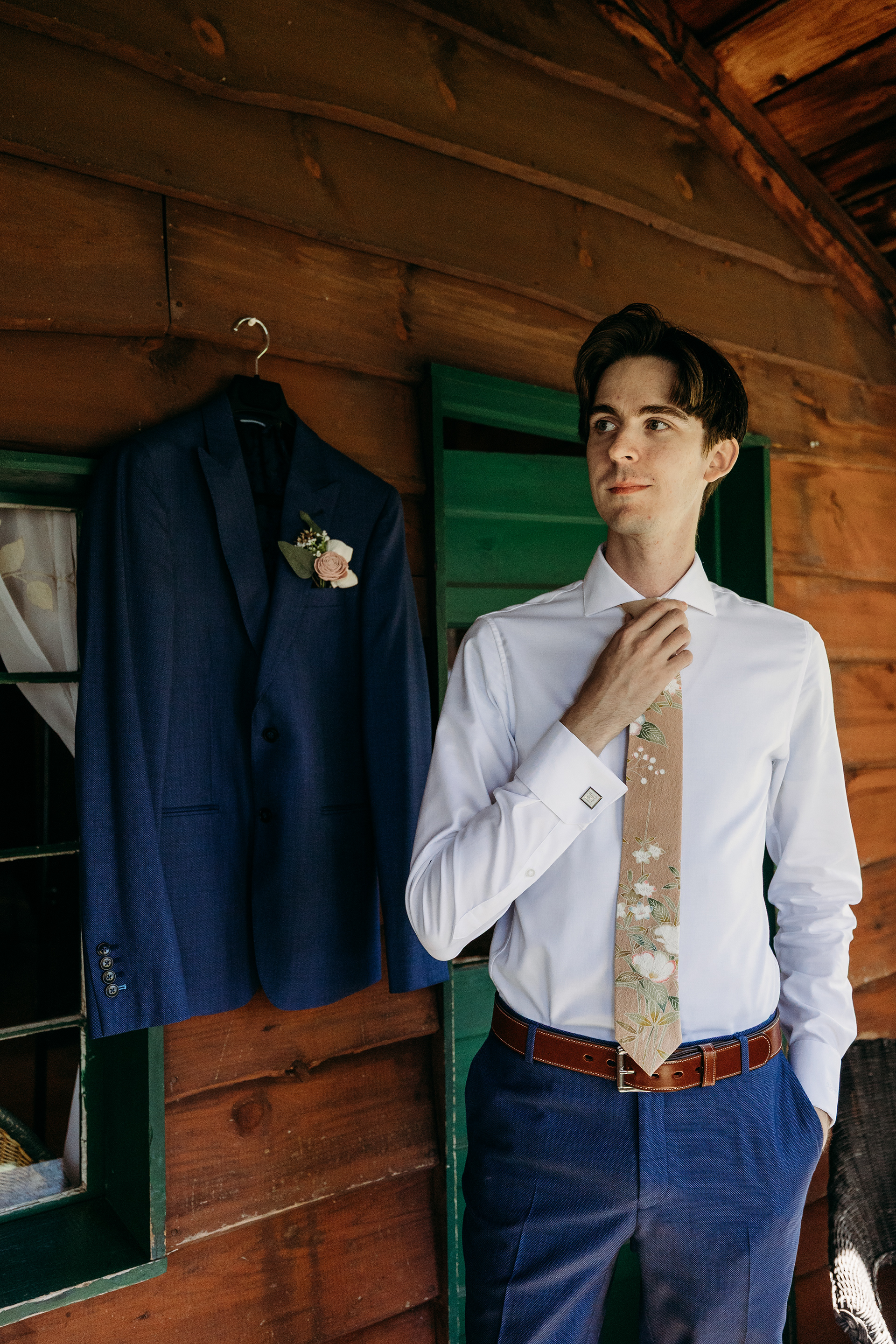 Nikolai adjusting his kimono tie in the Lakefield Cabin — small details like this make every NH wedding story beautifully personal.