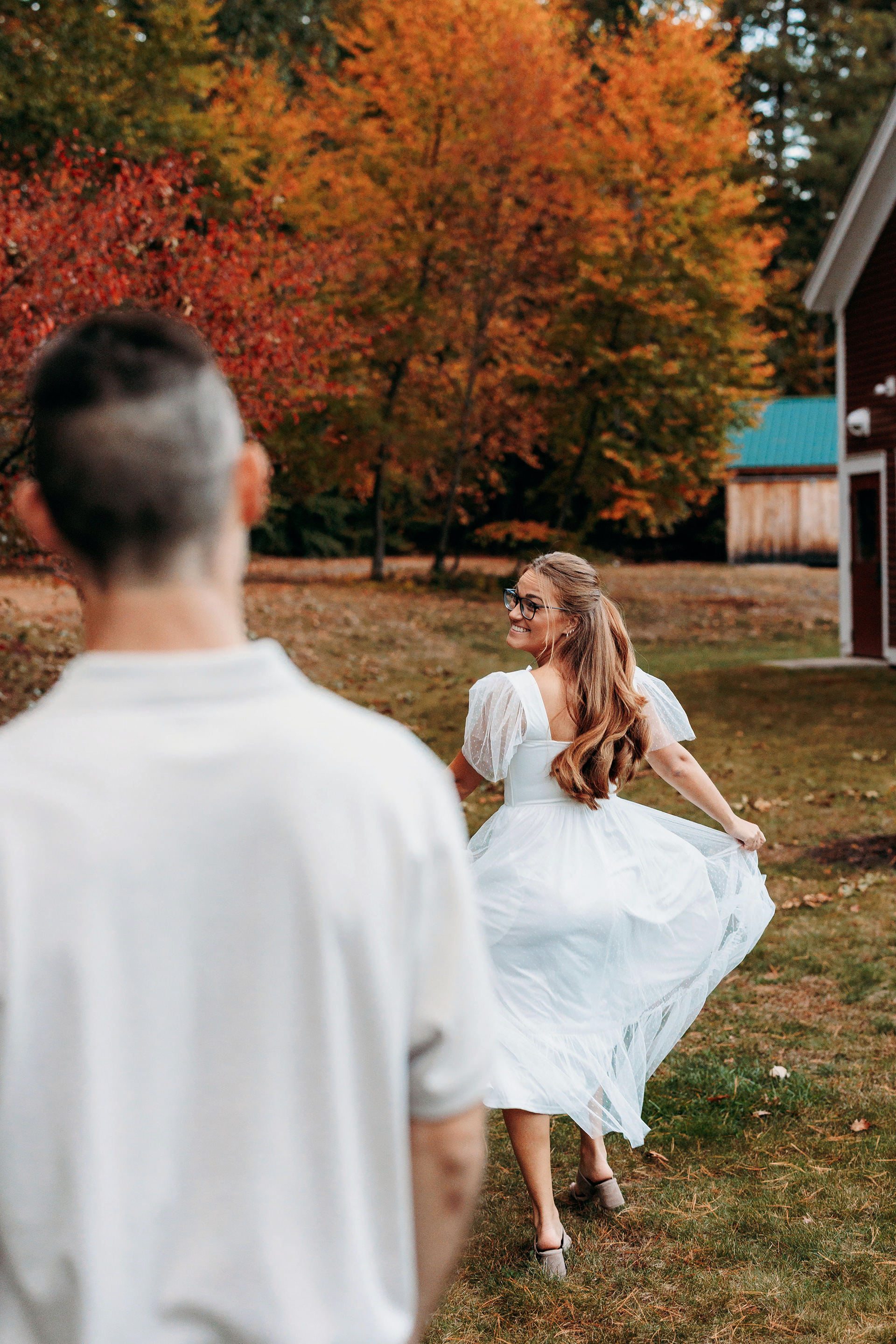 Playful laughter among the fall colors — a perfect New England engagement moment.