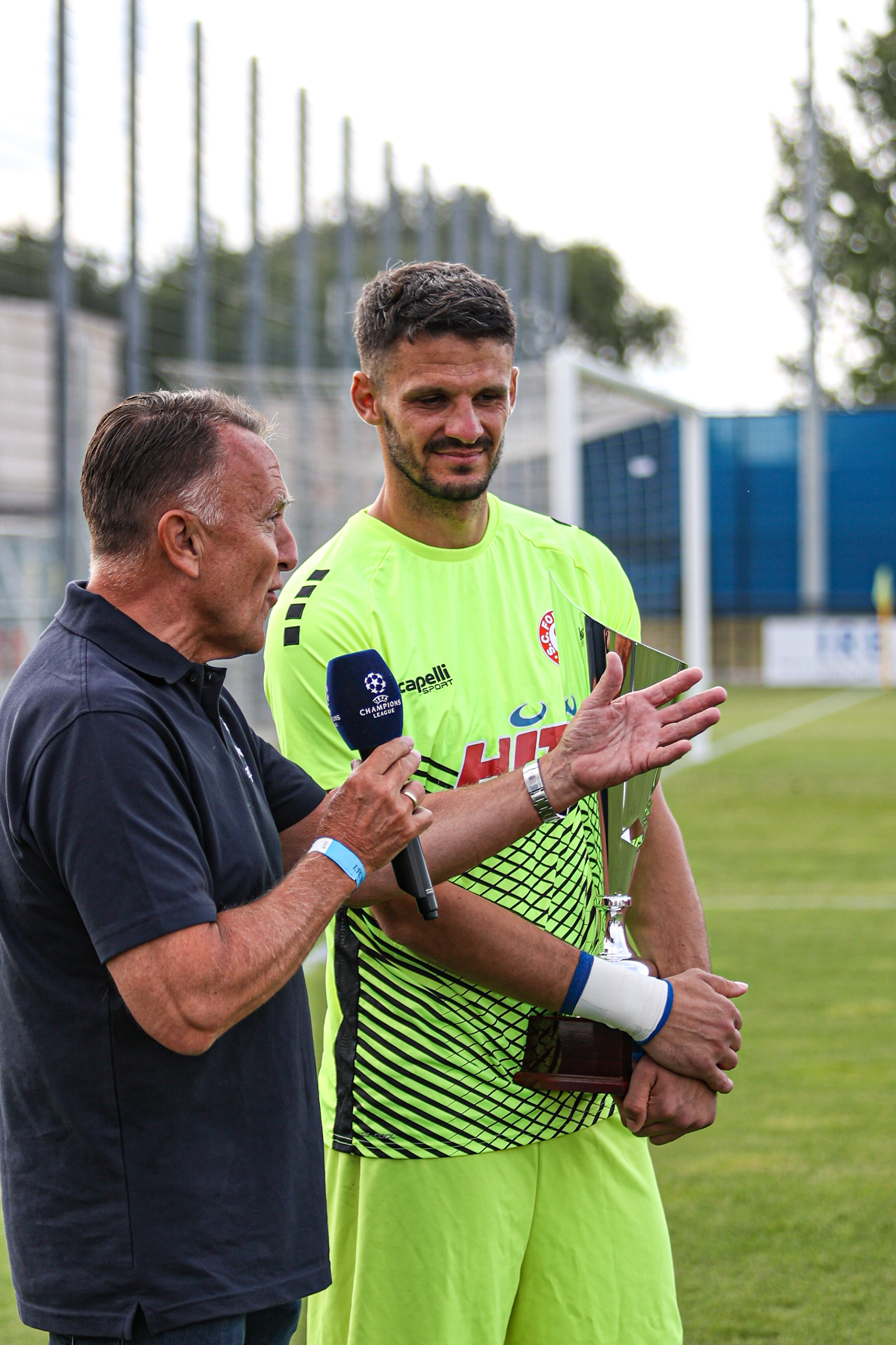 Thomas Boddenberg (l), Geschäftsführer bei apt Extrusions GmbH & Co. KG APT überreicht den Pokal an Torwart André Weis beim Rheincup 2022 im Rheinstadion des FC Monheim 1910 e.V. am 09.07.2022