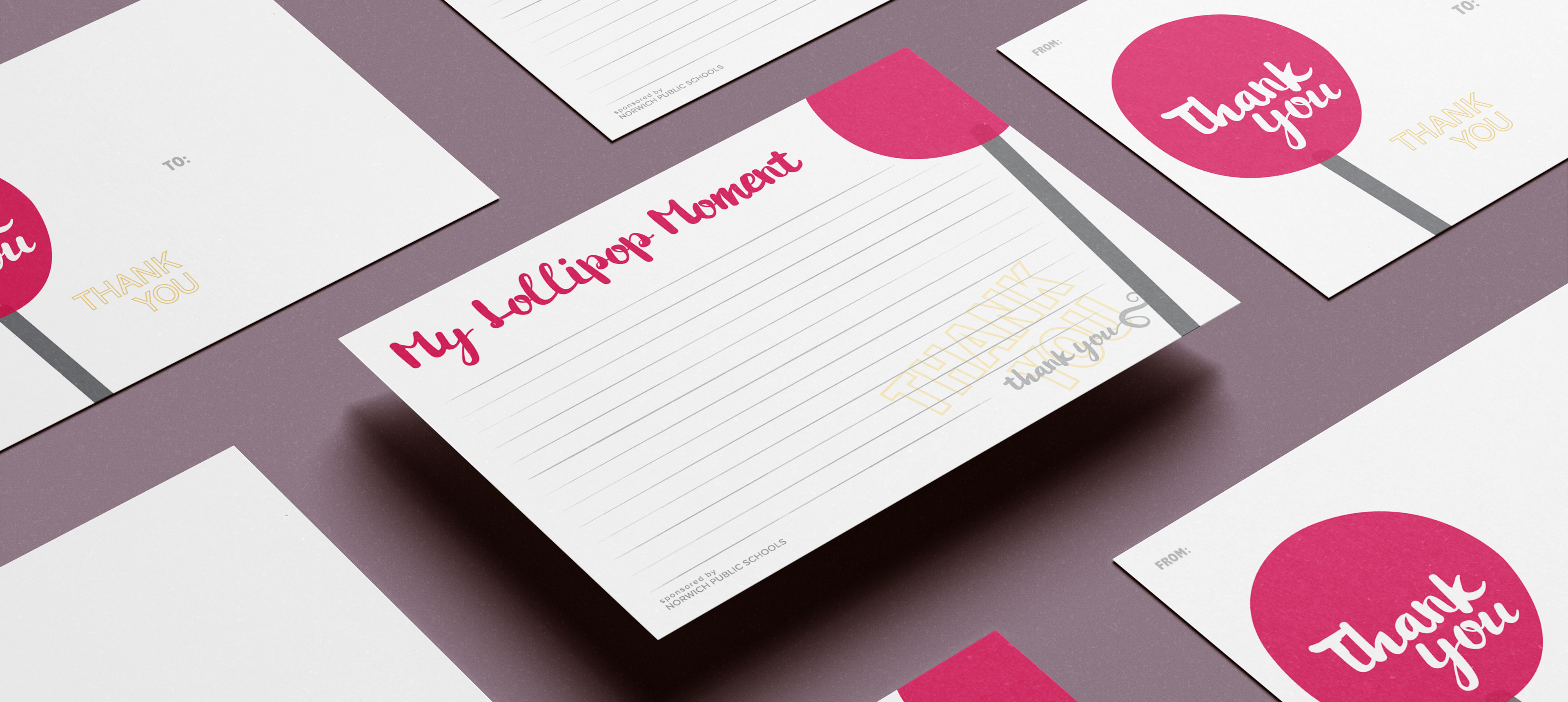 Editorial-style layout of multiple printed postcards arranged on a muted background, showing variations of the design including “Thank You” lollipop graphics and the “My Lollipop Moment” writing side, highlighting the cohesive visual system and print quality.
