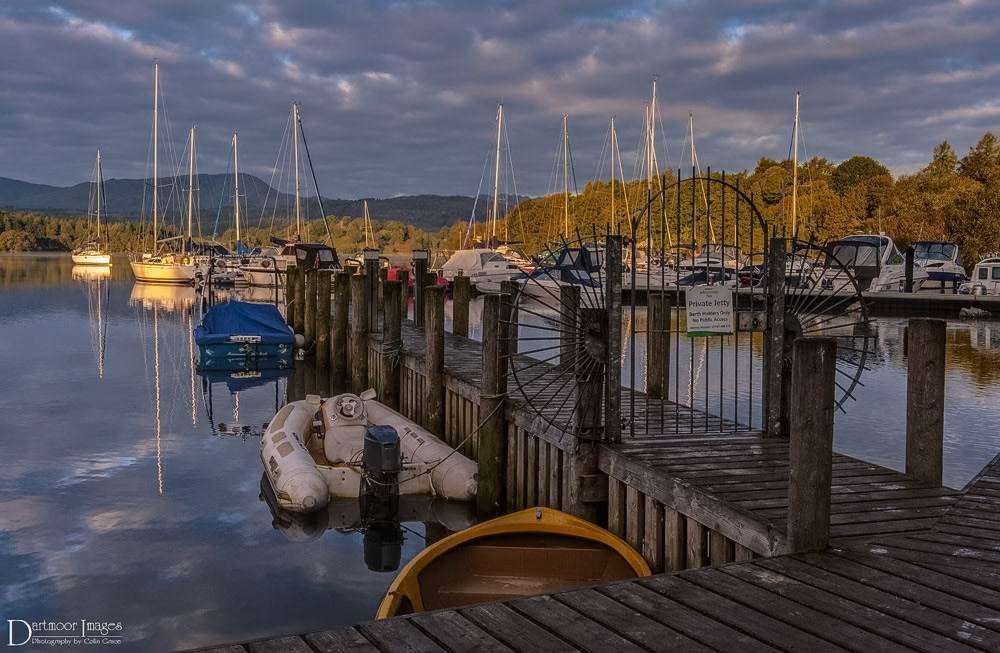 Yachts and boats moored alongside a private jetty at White Cross Bay, Windermere in the Lake District.